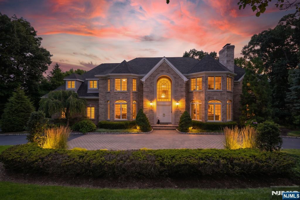 Custom-built in 1993 by its sole owner for entertaining, this 5-bed, 6-full & 2-half-bath estate sits on 1+ acre in the top-rated Franklin Lakes schools, behind a circular driveway, center paver walk, and an oversized 3-car garage with brick on three sides. Each bedroom has its own en-suite bath (1 main level, 4 upstairs). 4 fireplaces: great room, living room, primary suite, and basement family room (stone). A two-story foyer with grand staircase leads to a great room with a dramatic vaulted ceiling, palladian windows, built-in cabinetry, a 2-story fireplace, and French doors to a new, maintenance-free deck (roof 1 yr old). Chef's white kitchen offers an island, eat-in nook, and walk-in + butler's pantry. A second staircase leads through a mudroom landing (bench, cubbies, coat closet, powder room, garage access) and on to the kitchen. The primary suite has a front bump-out, walk-in + second closet, an in-floor heated bath with soaking tub, bidet, and its own fireplace, plus a sitting room/office with private balcony. A custom cherry-trimmed study features a coffered wood ceiling. The finished, furnished walk-out lower level has its own stone-fireplace family room, garage entry, 2 storage areas, concealed plumbing for a future kitchen, radon system, sump pump, and a 6th full bath beside a gym/office (egress window) with potential for a 6th guest suite. 100% hardwood floors, recently refinished. 5 zones of A/C, 11 zones of heat.