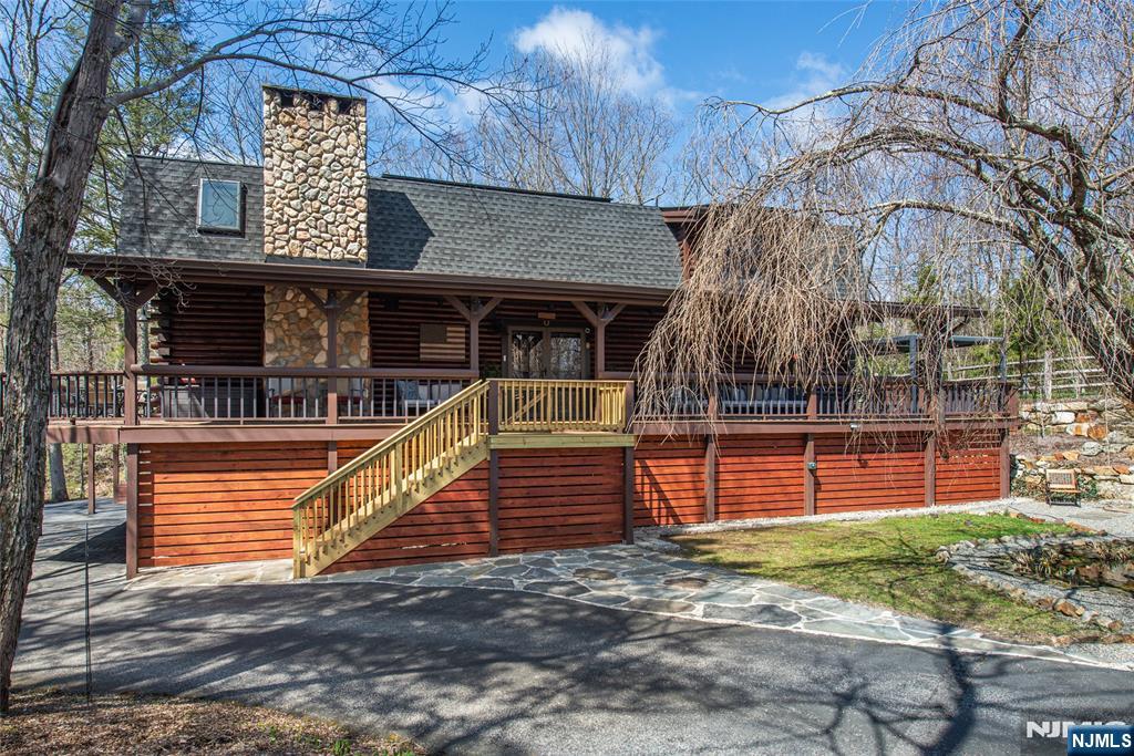 This custom-built post-and-beam log home offers a serene, year-round retreat with a perfect balance of rustic charm and modern efficiency. The open floor plan seamlessly connects the beautiful kitchen, dining area, and inviting living room, where a wood-burning stove adds warmth and character ideal for effortless entertaining. Step onto the expansive covered wraparound deck to take in panoramic views of your private property, complete with a tranquil koi pond and soothing stream. With three bedrooms, three bathrooms, a loft, two offices, and a fully finished basement featuring a spacious family/game room, this home provides abundant space for both work and relaxation. Soaring ceilings and exposed beams enhance the bright, airy atmosphere, while solar panels and custom heating/cooling wall units ensure exceptional energy efficiency. A true retreat where nature, comfort, and craftsmanship come together beautifully.