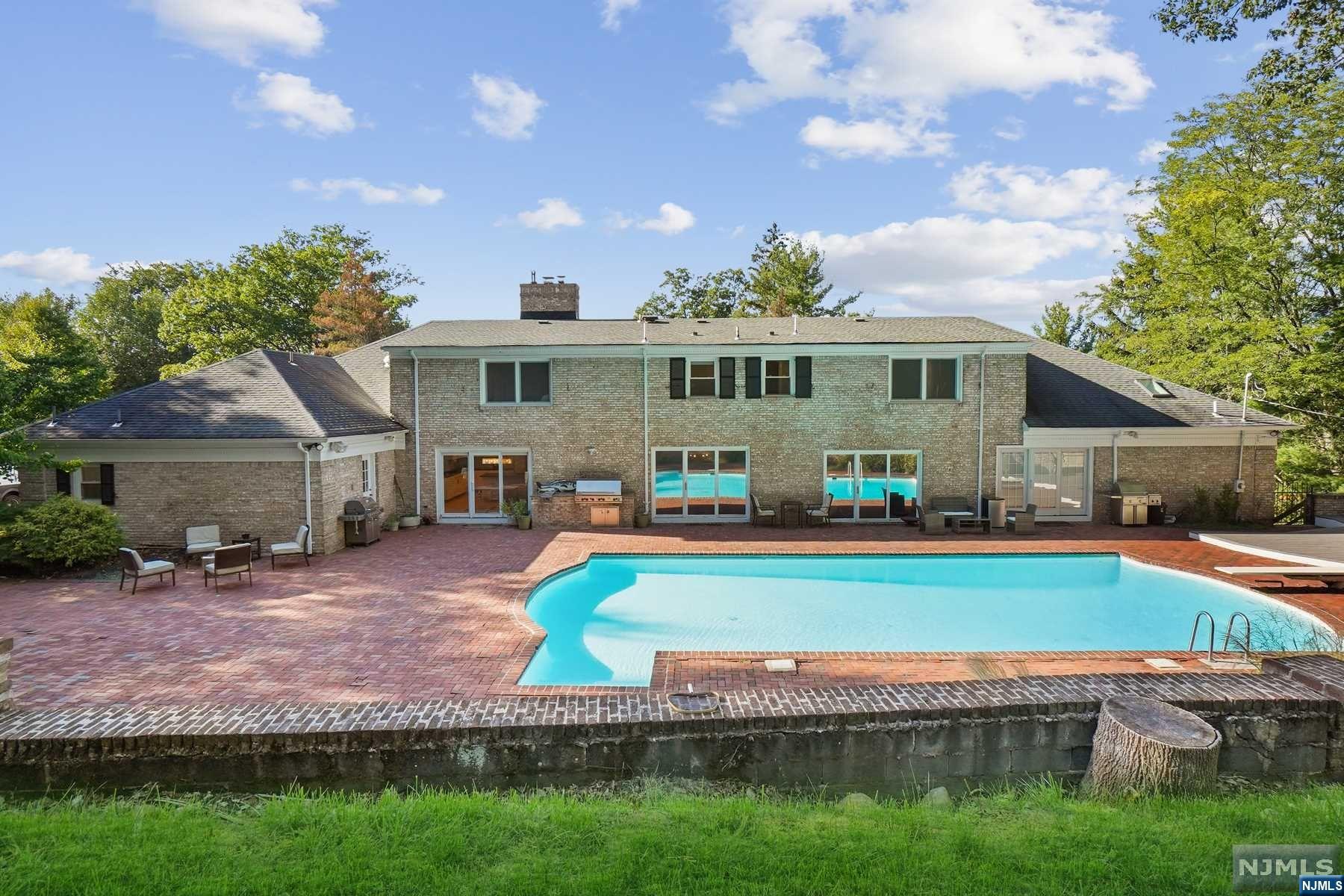 Short Hills show stopper located in sought after Deerfield Elementary section with 8000+ sq ft! Fully renovated 7/8 Bedroom, 6.1 Bath custom home on acre of private, lush property. Multiple levels of living and entertaining including resort-like heated pool. Foyer and grand curved staircase opens to Living Room with glass doors to patio; Dining Room; Library / Great Room and Powder Room. Eat-In Kitchen with granite countertops, high-end appliances, center island + built-in workspace. Laundry Area + Mudroom with access to 4-car garage + Bedroom next to a full Bath. 1st Floor Primary Wing features 2 en-suite bedrooms. Primary Suite includes walk-in closet/dressing room and spa-like Bath + direct pool access. Addl en suite bedroom. 2nd level with 3 large Bedrooms + optional Primary Suite. Lower Level- Rec Room with Wet Bar, cooktop, microwave + Gym,Sauna, Wine Cellar, 2nd Home Office, Studio/ bedroom with closet and egress window, Bonus Room with a closet, storage rooms + Full Bath.