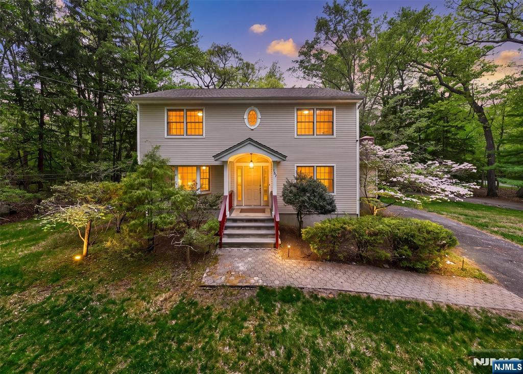 A rare opportunity in the heart of Ramsey, this east-facing Colonial sits on nearly two acres and offers the privacy, space, and potential that is increasingly hard to come by. Call 201-908-4663 for a tour. Whether you are looking to move right in, build your dream estate, or explore investment potential, this property delivers. The expansive grounds back to unspoiled forest with room for a pool, sports court, gardens, or simply the freedom to enjoy nature. The west-facing backyard means afternoon sun through sunset, ideal for outdoor entertaining on the expansive deck. Inside, four spacious bedrooms, two full bathrooms, and over 2,000 square feet flow naturally throughout. A 2020 addition enhanced the footprint, while high ceilings, a fireplace, and fresh paint create warmth and character. An enclosed porch, open porch, and sun-drenched deck bring western views over the forest. The walk-out lower level adds almost 500 square feet, perfect for a gym, media room, or home office. With a newer roof and refreshed interiors, you can settle in immediately. Located on a tree-lined street across from the middle school, you're minutes from downtown Ramsey's dining & shopping. Free commuter parking connects you to Manhattan via NJ Transit, just 30 miles away. The Appalachian Trail is three miles from your door, premier shopping within 10 miles. Nearly two acres backing to pristine forest with western exposure and unbeatable location. Properties like this don't surface often.