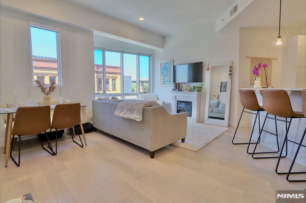 Welcome to the Cornerstone Lofts, a boutique condominium building in the heart of Downtown Jersey City. This 1-bedroom, 1-bath home features 10-foot ceilings, floor-to-ceiling windows, abundant natural light, automatic blinds, central air, and an in-unit washer/dryer. The kitchen is finished with custom-designed lacquer cabinetry, quartz countertops, and a fully vented hood, with an open layout that makes the space feel modern without being overdone. The building offers a private rooftop gym with a Peloton, plus a rooftop terrace with grills, a fire pit, a turf lounge area, and NYC skyline and Hudson River views; perfect for hosting or relaxing outdoors. Parking is available adjacent to the building. Located just minutes from Grove Street PATH, restaurants, cafes, shops, and nightlife, this home offers luxury, convenience, and quick access to NYC from Jersey Cityâ€™s most desired neighborhood.