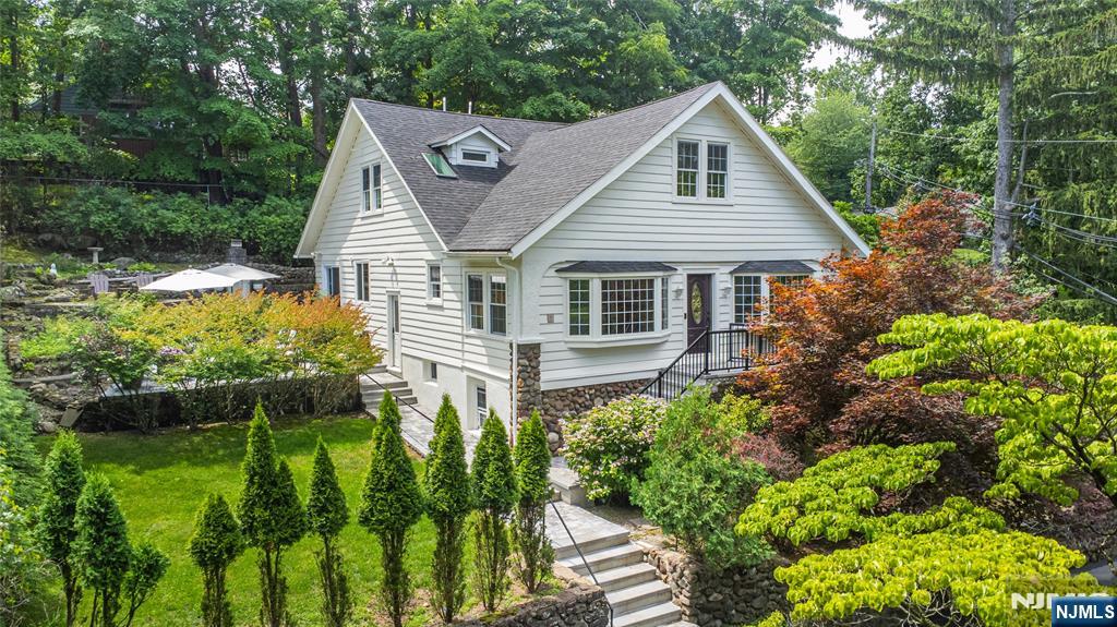 Quiet street, top-tier schools & easy NYC access. Tucked away on a peaceful street surrounded by mature landscaping, 8 Birchwood offers exceptional privacy in one of Essex County's most sought-after communities. Inside, spacious living areas (2422 SQFT + Basement) flow effortlessly throughout. The living room opens to the dining area, while the beautifully updated kitchen offers abundant cabinetry & quality finishes. Renovated baths, designer lighting, custom millwork & countless upgrades create a home that's stylish, effortless & move-in ready. The flexible floor plan features generously sized bedrooms, inviting gathering spaces, dedicated office space & a spectacular finished lower level with a custom entertainment wall, built-in shelving & endless versatility for recreation, a gym or working from home. Outside, professionally designed stone patios, terraced landscaping, lush gardens & a stunning outdoor fireplace create a private setting for entertaining & relaxing. Notable upgrades include updated electrical, energy-efficient windows & insulation, high-efficiency 2 speed heating & AC, updated roof, renovated gas fireplace, renovated bathrooms & two recently installed driveways. The North Caldwell lifestyle offers beautiful parks, convenient NYC transportation, easy access to Caldwell & Montclair's vibrant restaurant scene, plus the highly regarded West Essex school system.