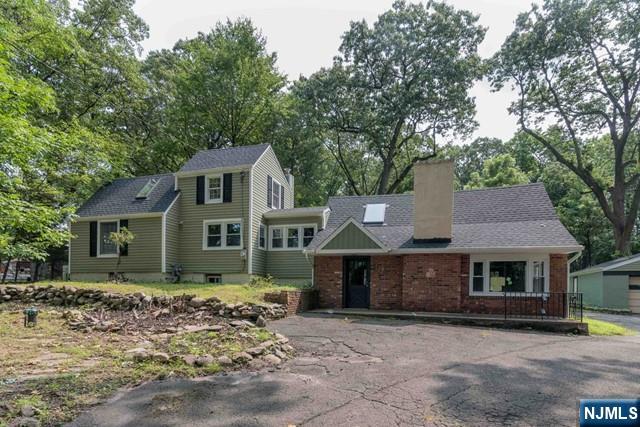 Welcome to this beautifully updated 2-bedroom, 2-bath cottage set on a picturesque 1-acre property in desirable North Haledon. Offering the potential for a third bedroom, this versatile home provides flexible living space to suit a variety of needs. Upon entering, you'll find a spacious ground-level family room filled with natural light and highlighted by a cozy wood-burning fireplace. The main living level features a recently updated kitchen with newer appliances, ample counter space, and modern finishes, along with a comfortable living room and a bonus room that can serve as a dining room, home office, or third bedroom. A convenient laundry area with a washer and dryer and additional storage completes this level. Upstairs, two generously sized bedrooms are thoughtfully positioned on opposite sides of the home, providing added privacy. Both bathrooms were renovated approximately two years ago and feature stylish fixtures and attractive tilework. Additional highlights include newer windows, central air, and numerous updates throughout. Ideally located near the Wyckoff border and just minutes from downtown Ridgewood, this charming home combines modern amenities with a peaceful setting. With its thoughtful updates and attention to detail, this is a must see!