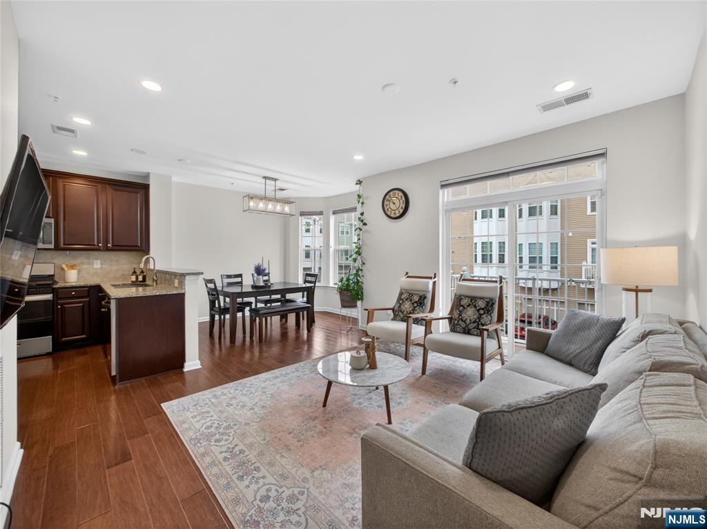 NORTH-EAST ENTRANCE! BEAUTIFUL STARTER HOME offering effortless living in one of Bergen Countyâ€™s most convenient and sought-after communities! This SUN-LIT townhome in Liberty Square, Wood-Ridge features 2 BEDROOMS, 2.5 BATHROOMS, and approximately 1,771 SQ FT of thoughtfully designed living space blending comfort, privacy, and modern style. A lush green front courtyard creates a peaceful outdoor retreat, while the ATTACHED 1-CAR GARAGE PLUS 1-CAR DRIVEWAY provide everyday convenience. Inside, enjoy HARDWOOD FLOORS, GRANITE COUNTERTOPS, STAINLESS STEEL APPLIANCES, MODERN CABINETRY, a raised breakfast bar, RECESSED LIGHTING, PANTRY, NEW CARPET, FRESH PAINT, and an OPEN-CONCEPT layout ideal for entertaining and daily living. The LARGE FAMILY/GATHERING ROOM offers the perfect recreation or entertainment space. The MASSIVE PRIMARY SUITE features CATHEDRAL CEILINGS, a HUGE WALK-IN CLOSET, and a spa-like primary bath complete with a LARGE SOAKING TUB, DUAL VANITY, and STAND-UP SHOWER. Enjoy LOW-MAINTENANCE LIVING with one of the LOWEST HOA FEES IN NORTH JERSEY, INCLUDING WATER, EXTERIOR MAINTENANCE & ROOF COVERAGE. Enjoy RESORT-STYLE AMENITIES, an ON-SITE TRAIN STATION, direct Manhattan buses every 10â€“15 minutes, easy highway access to NYC, Hoboken, Jersey City & Secaucus, close proximity to Catherine E. Doyle Elementary School & RETAIL STORES within the community for added convenience.