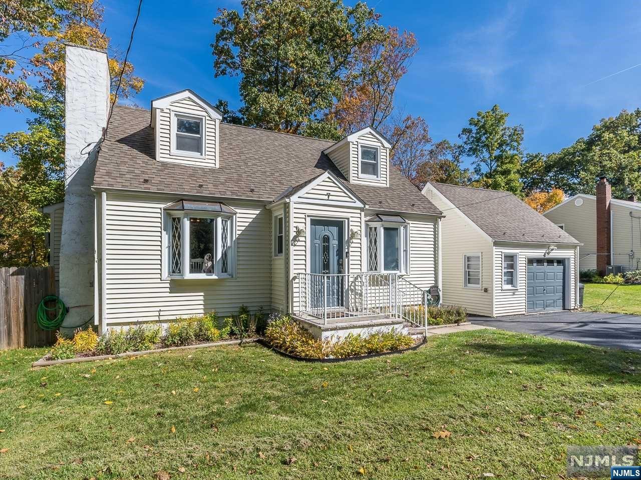 Tastefully updated Cape-Cod home situated on a large level lot! This home features is conveniently located near NYC transportation, schools and shopping. Greet your guests in the entry foyer, which leads to the living room and dining room. The living room is spacious and features large bay window that allows plenty of natural light to fill the room. The dining room offers brick-faced fireplace. This is the perfect space for holiday dinners or just a quiet night at home. Open concept floor plan allows the dining room to flow seamlessly into the updated kitchen. The kitchen features custom cabinetry, stainless steel appliances and granite countertops. The first floor offers one bedroom and full bathroom with tub shower and storage vanity. Retreat upstairs to find 2 sizable bedrooms and a half bathroom. The finished basement offers den area, laundry room and plenty of storage space. The fenced-in backyard is spacious and totally private! Detached garage & driveway with ample parking.