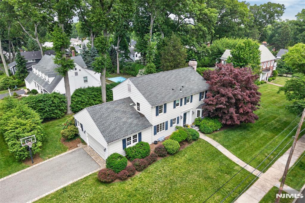 Located in Ridgewood's coveted Willard School District, this turn-key 4-bedroom, 3.5-bath Center Hall Colonial offers timeless curb appeal and style all while set in an A+ neighborhood setting. A gracious entry foyer welcomes you to a functional layout where hardwood floors, custom millwork, and indoor-outdoor audio system set the tone throughout. The thoughtfully designed main level features a private office with French doors, a formal dining room, and an inviting family room with a fireplace and French doors opening to a covered porch and a professionally landscaped backyard. The bright & freshly painted kitchen is the heart of the home, offering a center island, quality cabinetry, and seamless flow through an eat-in space into the mudroom and attached two-car garage. Upstairs, offers 3 spacious bedrooms, a full hall bath, and a primary bedroom with an ensuite bathroom and dressing room area. The finished lower level expands the living space with a home theater/lounge area featuring a stone-front gas fireplace, a full bath, and a dedicated home gym with a wall of mirrors. A rare combination of location, modern convenience, character, and value - this is the Willard home you've been waiting for!