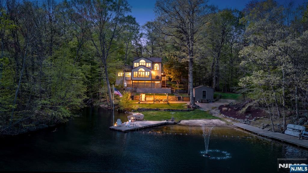 Experience one of the most extraordinary lakefront settings in the tri-state area, where sweeping water views, unmatched privacy, and a true sense of escape define everyday living. Set within the exclusive Lake Iosco community, a 400 acre private lake shared by just 43 residents, this property offers a rare lifestyle just moments from NYC. Live and entertain as the property offers: its own private sand beach, multiple docks, two boat houses including one fully enclosed, and outdoor space designed to embrace the waterfront. Enjoy boating, fishing, swimming, and endless lake activities directly from your property. The home features an open layout with walls of glass capturing the lake, a main level bedroom, and a second floor devoted to a primary suite with breathtaking views. The walkout lower level adds additional living space and flexibility. Home is a 2 bedroom for tax purposes, but a functional 3 or 4 bedroom. Schedule your private tour today.