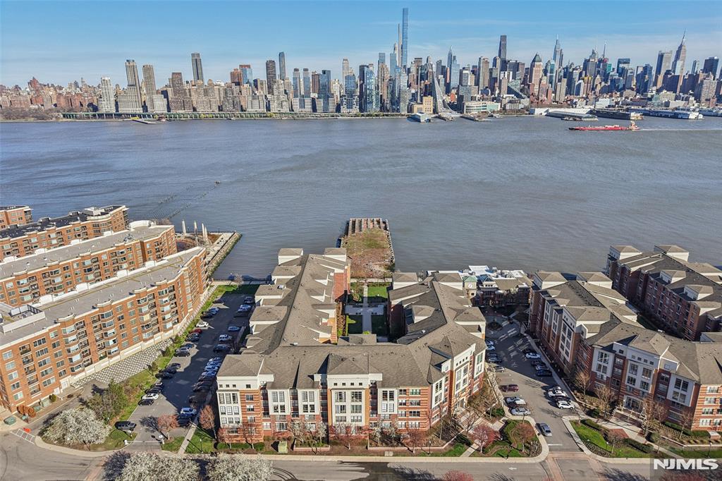 Experience the pinnacle of Gold Coast luxury in this rarely available, renovated penthouse duplex at Hudson Club. Perched along the Port Imperial waterfront, this exquisite 1,300+ sq. ft. residence features soaring double-height ceilings and sweeping, unobstructed NYC views from every room. Bathed in natural light, the open-concept floor plan showcases hardwood floors, industrial-inspired white-washed brick accents, and a chic designer kitchen with a breakfast bar that connects to a spacious living and dining area. The primary suite offers a spa-like renovated bath, while in-unit laundry, 2 walk-in closets, and a designated parking space add ultimate convenience. Residents enjoy a seamless, all-inclusive lifestyle, with maintenance covering access to clubhouse, pool, 1 parking, cable, water and garbage. Residents of Hudson Club enjoy an impressive array of resort-style amenities, including a concierge, outdoor pool with jacuzzi, fitness center, basketball court, cinema room, social lounge, business centers, fire pits, and more. An effortless NYC commute is guaranteed with the NY Waterway Ferry and NJ Transit just steps away, while ACME and Starbucks are right at your doorstep. Live above it all in West New Yorkâ€™s most sought-after waterfront community.