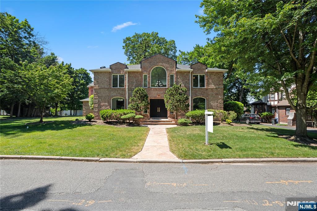 Welcome to 30 Creston Avenue, East Hill Tenafly NJ, a stately manor-style brick Colonial that blends classic architecture with dramatic, modern design spanning 5,500+ Sq ft. Soaring ceilings, wrought iron banisters, an open atrium, and custom stained glass create a striking first impression, while a second-floor gallery adds warmth and artistry throughout the home. The main level offers a gracious living room with fireplace, formal dining room opening to an oversized deck, and a large eat-in kitchen overlooking the expansive backyard-ideal for everyday living and entertaining. A dedicated office and family room provide flexible space for work, relaxation, or play. With 6 generously sized bedrooms and 4 bathrooms, including a primary en-suite, this residence offers exceptional versatility and space. The thoughtful layout centers around a bright atrium that naturally connects the main living areas, enhancing flow and functionality. The fully finished basement extends the living space with a recreation and gaming area, convenient laundry, and abundant storage. Distinctive details such as the Belgian antique fireplace mantel and custom finishes throughout set this home apart from typical Colonials. Located close to schools & transportation to NYC, and local amenities, this home combines style, convenience, and substantial living space. This well-appointed brick Colonial with a spacious yard and exceptional quality design is a rare and special Tenafly offering that won't last.
