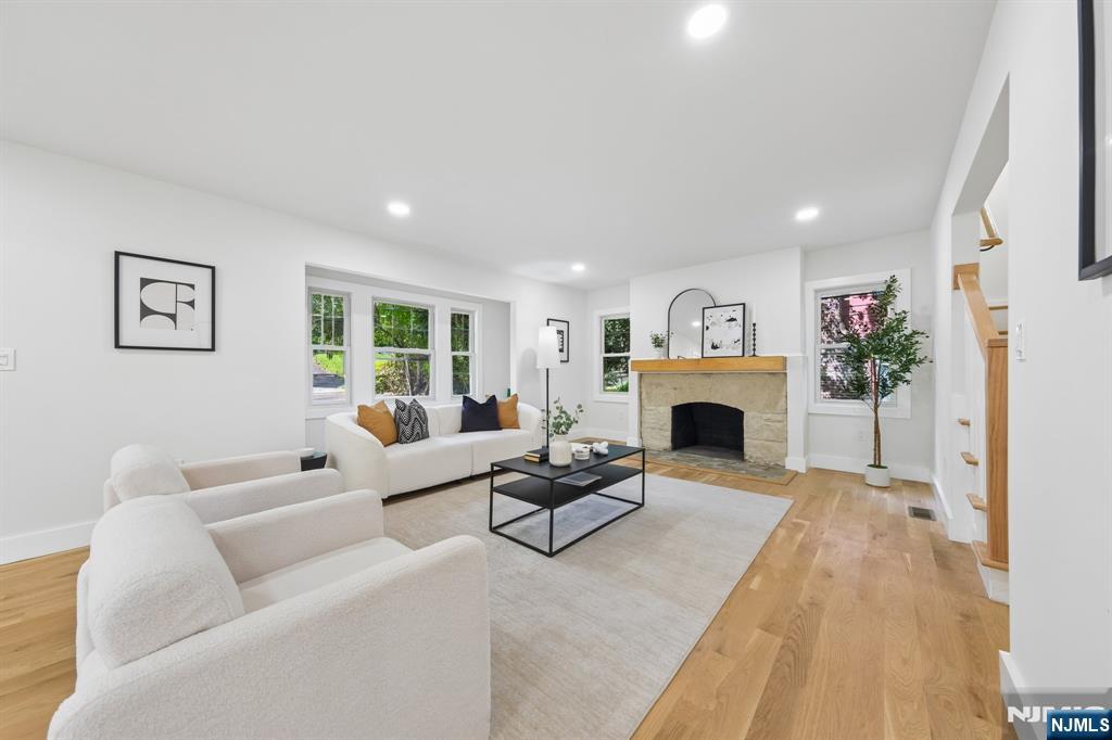 Experience a Modern Tudor Revival where classic architecture meets refined, contemporary design. Thoughtfully reimagined with elevated finishes, clean lines, and timeless detail, this fully renovated home offers 4 bedrooms, 3 full baths, and 2 powder rooms across three levels of living space. The thoughtfully designed layout is ideal for both everyday living and entertaining. The main level features a welcoming living room with a wood-burning fireplace, a formal dining room, and a home office. The chef-inspired kitchen is a true centerpiece, complete with a dedicated coffee bar and seamless flow into a bright breakfast/sunroom. Expansive living continues with a family room, recreation room, and a stylish wet bar, offering multiple spaces to relax and gather. The home offers two en suite bedrooms, providing flexibility and comfort for modern living, along with a dedicated laundry room for added convenience. Additional highlights include an oversized garage equipped for EV charging and a seamless blend of timeless character with contemporary functionality throughout.