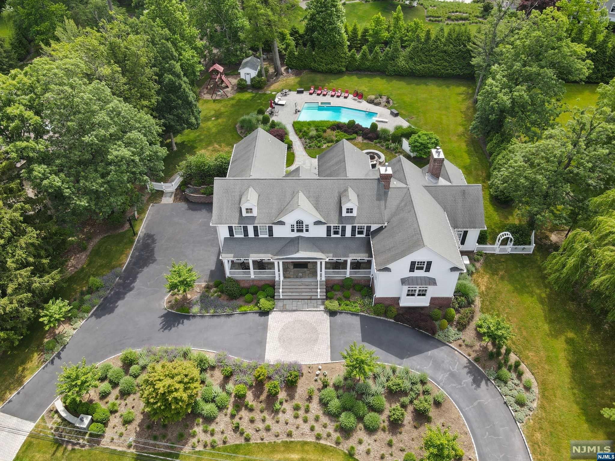 Welcome to the coveted E.Hill of Tenafly. Set back & perched high, a picture perfect hamptons style beauty. A soaring 2-story entry floods the house w/nat light. Enjoy the sunset view from your DR & LR where dbl French glass doors open to a blue stone covered patio. A massive EIK w/beautiful cabinetry wolf & subzero APPL, radiant heat & lrg cntr island flow into the family rm accented by lrg windows & FPLC. Indulge in the 1st-floor home theater, offering the ultimate cinematic experience. Catering to discerning buyers, a 1st-floor bdm w/bth also serves as the indoor cabana. Upstairs, 4 lrg bdrms incl a serine primary suite w/vaulted ceilings, radiant bath & his/her WIC's. Addl ensuite bed/bth w/stunning views of the back yrd & 2 addl spacious bdrms w/WIC's share a well-appointed bthrm. Enjoy a backyard oasis, complete w/pool, hot tub, oversized blue stone patio & high-end outdoor kitchen ft refrigerator drawers & cozy fire pit, while green giants provide year-round seclusion.