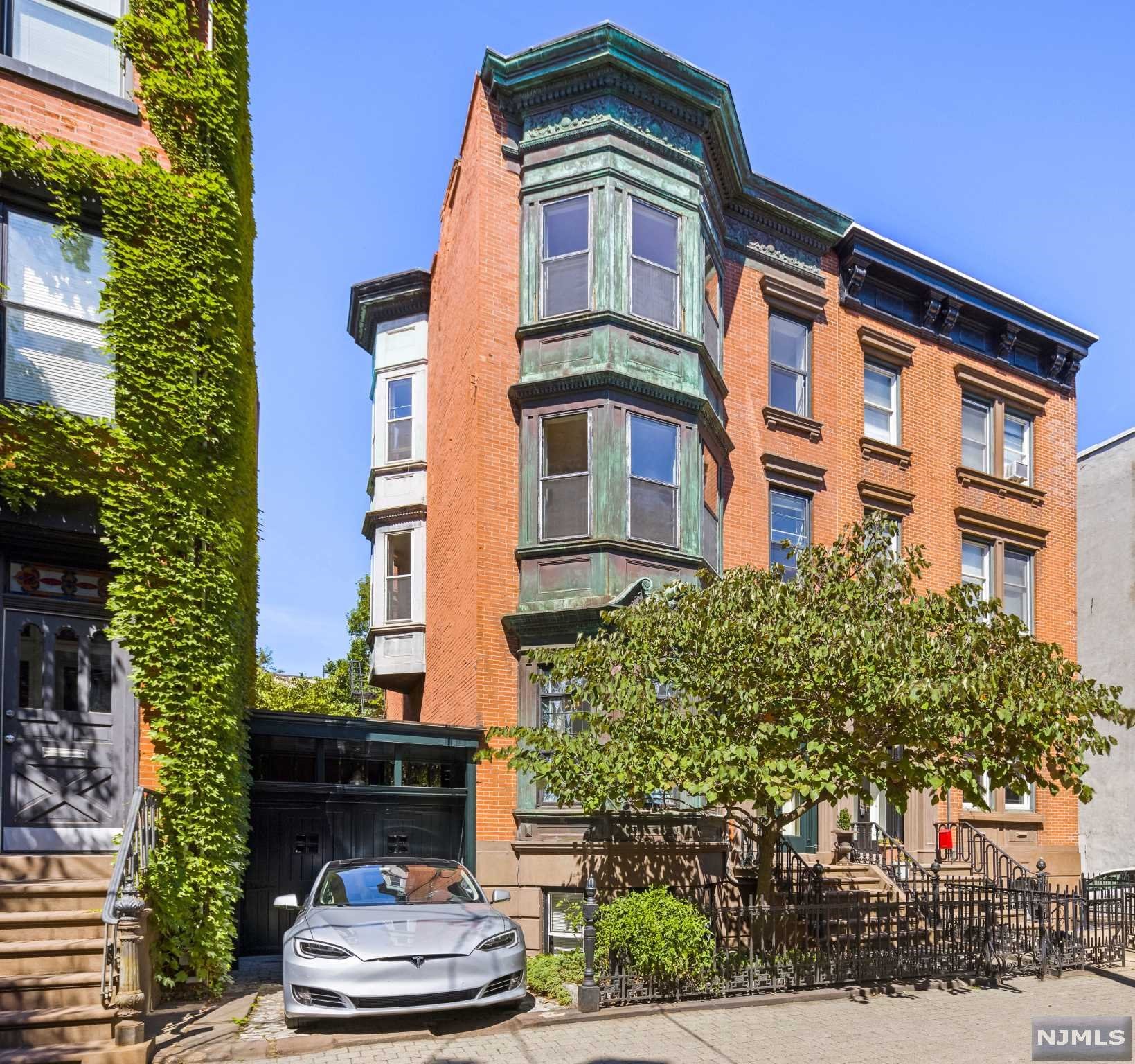 624 Bloomfield Street is a rare and important property, a piece of Hoboken history that is comprised of two distinct buildings connected by a brick breezeway encompassing a lovely courtyard garden located on an oversized lot that provides parking in a prime midtown Bloomfield Street location. The oversized 31 x 100 ft lot consists of an exceptional 21' wide four-story semi- attached townhouse featuring stunning four story copper clad projected bay windows on the front fa ade and a two-story bay window on the southern elevation that offers rare multiple exposures. The main townhouse is attached to a two-story carriage house towards the rear of the property and a single story bay garage with wicket door to the south providing both on and off street parking. The handsome circa 1850 townhouse incorporates elements of the Renaissance Revival, Neo-Grec and Italianate architectural styles. The gracious main entry is recessed and composed of a double leaf, wood and glass paneled door...