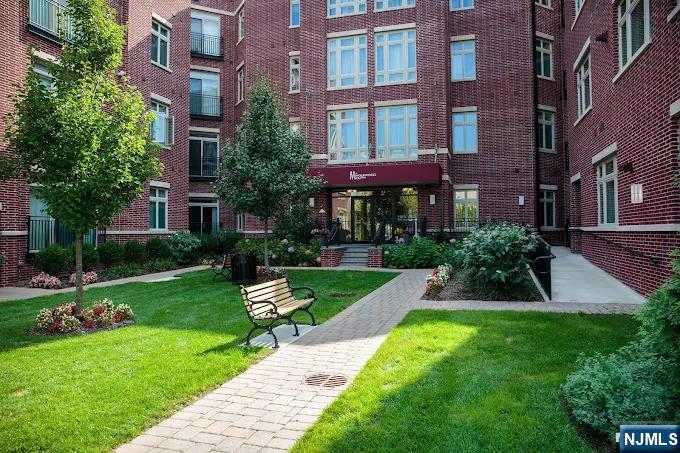 Welcome to The M at Englewood South. This rare top-floor corner unit offers approximately 1,500 sq. ft. of living space, exceptional privacy, soaring ceilings, high windows, and beautiful natural light across an L-shaped north, west, and south exposure. With windows on multiple sides and no unit above, the home feels bright, quiet, and elevated throughout. This spacious 2-bedroom, 2 full bathroom, 1 half bathroom. The large living and dining area flows seamlessly into the open kitchen, creating an ideal layout for entertaining, everyday comfort, and flexible furniture arrangements. A Juliet balcony off the living room brings in additional light and fresh air, while hardwood floors, high ceilings, and abundant natural light give the space an open, airy, and inviting feel. The generously sized primary suite includes an en-suite bath, while the second bedroom and additional full bathroom are perfect for guests, family, or a home office. A separate powder room adds extra convenience for daily living and entertaining. Additional highlights include private indoor garage parking, elevator access, and community amenities including a pool, resident lounge, playground, and pet-friendly living. Conveniently located near NYC bus service, Route 4, major highways, downtown Englewood shops, restaurants, parks, and everyday essentials, this move-in-ready home offers comfort, privacy, and convenience in one of Englewoodâ€™s most amenity-rich communities.
