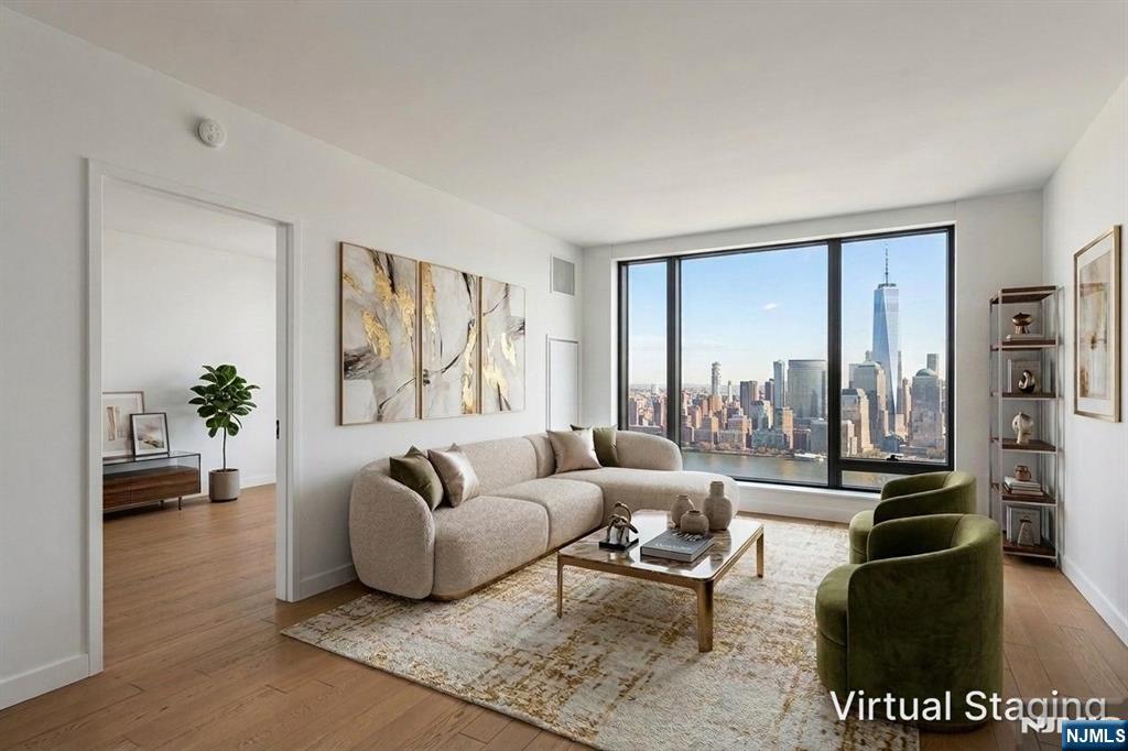 Spacious and elegantly designed two-bedroom, two-bathroom residence with parking, located at 99 Hudson St. This home features a bright, open-concept layout, highlighted by beautiful views of the New York City skyline. The modern kitchen is thoughtfully designed with abundant cabinetry and equipped with high-end appliances. The primary suite offers two generous closets and a luxurious en-suite bathroom. The second bedroom is well-proportioned and includes a sizable walk-in closet. Residents are welcomed by a stunning lobby, complete with a 24-hour doorman and concierge services that provide a true hotel-like experience.Enjoy the expansive outdoor swimming pool, host gatherings with outdoor grilling and dining areas, or spend time in the game room, lounge, or library. The thoughtfully curated amenities also includes private cabanas, a landscaped lawn, the Hudson Club Room with dining and lounge areas, a demonstration kitchen, business center, childrenâ€™s playroom, screening room, golf simulator, and an outdoor dog run. For wellness and relaxation, residents have access to a full-service spa facility featuring a hot tub, dry sauna, steam room, and reservable massage treatment rooms. Perfectly positioned along the waterfront, 99 Hudson offers a lifestyle that blends luxury, convenience, and community. Conveniently located 3 blocks from the Exchange Place Path station and the Ferry.