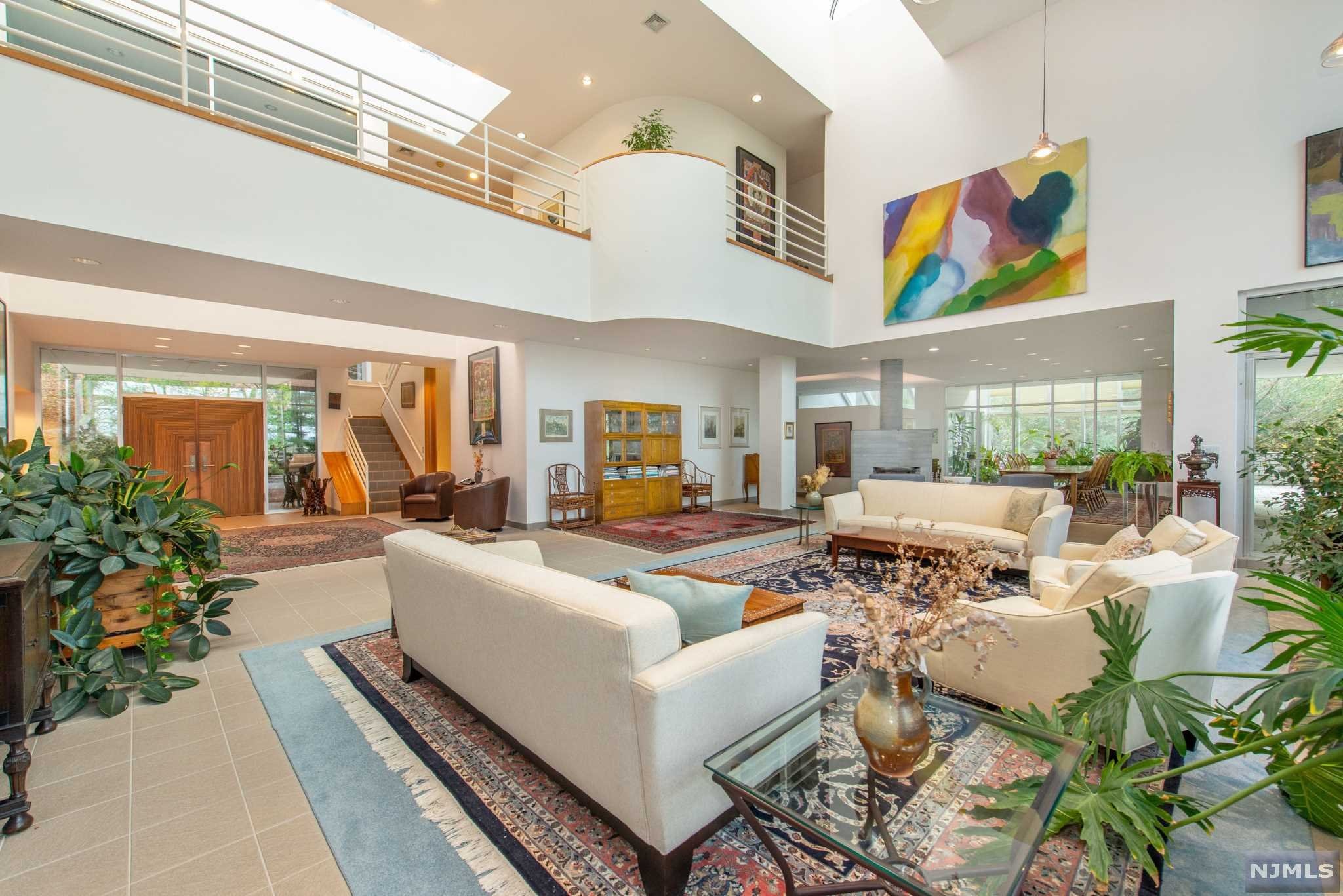 Luxurious CONT interior in this spacious 10,233 sq ft. home with soaring ceilings, walls of glass allowing for sun-soaked rooms, soapstone WDBRN STV, SGDS to BALCS from nearly every richly appointed room. Endless amounts of peace and privacy on over 2 acres of manicured lush grounds wait at the end of a private road. The home accommodates one-floor living with one of 2 MBR suites on the 1st level. Impressive 2nd-floor family room is an entertainer's dream and the 3-story Home Theater allows for endless possibilities. The lower level boasts Olympic size length lap pool with a cabana, kitchenette, and full gym. Unique features include a 3 car garage with an electric charging station, whole house generator, and upgraded solar system. Award-winning SCHL SYS. Mins from Manhattan.