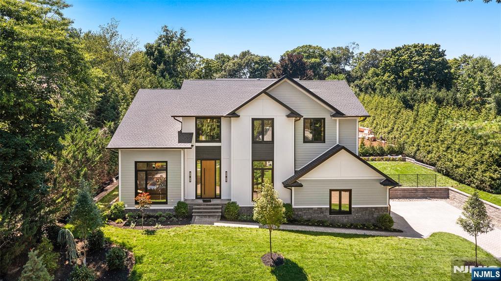 Experience luxury living in this exceptional new construction by Lumaj Properties, offering over 6,000 square feet of beautifully designed living space with 6 bedrooms and 5.5 baths. Superior craftsmanship and sophisticated design are showcased throughout. A grand foyer welcomes you into sun-filled interiors featuring soaring 11-foot ceilings on the main level, 10-foot ceilings on the second floor, and 9-foot ceilings in the finished lower level. The chef's kitchen is a true centerpiece, featuring premium Thermador appliances, a built-in Bosch coffee system, custom cabinetry, an oversized island, and a 92-bottle wine refrigerator. A first-floor bedroom with a full bath opens directly to the backyard, ideal as a pool cabana, guest suite, or home office. The second level offers a luxurious primary suite with a spa-inspired bath and oversized walk-in closets, plus three additional bedrooms with radiant heated bathroom floors. The finished lower level includes a movie theater, recreation area, additional bedroom and full bath, and a storage or gym room. Enjoy resort-style outdoor living with a heated Gunite pool, sun shelf, and professionally landscaped grounds. Additional amenities include three-zone HVAC, exterior security cameras, underground utilities, a full-house generator, and smart home features. A rare opportunity to own an extraordinary home where luxury and resort-style living come together.