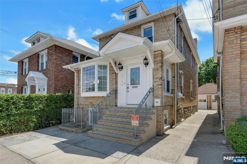 Welcome home to this beautifully renovated two-family residence in one of North Bergen's most desirable locations, just moments from Braddock Park with an easy commute to NYC. Blending classic charm with modern updates, this exceptional home features high ceilings, beautiful woodwork, and an abundance of natural light that creates a warm and inviting atmosphere throughout. The main unit offers three spacious bedrooms, a bright and open living area, and a beautifully renovated kitchen featuring granite countertops, a tile backsplash, stainless steel appliances, and abundant counter space. A walk-up attic provides excellent potential to be finished for additional living space. Hardwood floors, elegant moldings, central air, and an in-unit washer and dryer complete this move-in-ready home. The ground-floor apartment features one bedroom, a spacious living room, an eat-in kitchen, and a full bath, making it ideal for rental income, extended family, or guests. With all separate utilities, this property is perfectly suited for both owner-occupants and investors. Outside, enjoy a covered porch, a private backyard, a shared driveway, and a garage. Ideally located near the expansive Braddock Park, award-winning restaurants, shopping & everyday conveniences, this home also offers an unbeatable commute with the NYC bus stop directly outside your door. A rare opportunity to own a fully renovated, income-producing property in a prime North Bergen location with convenient access to NYC.