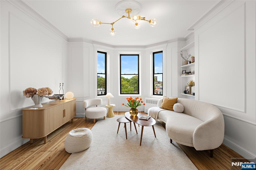 Perched atop a historic limestone building, this beautifully maintained penthouse condo blends pre-war charm with modern elegance. Soaring ceilings, antique moldings, custom smart lighting, and refinished hardwood floors create a warm, elevated atmosphere. The sun-filled front parlor, framed by bay windows, captures sweeping views of Hoboken rooftops, treetops, and the Manhattan skyline - from One World Trade Center to the Empire State Building. A subtle flush inset door blends seamlessly into the trim, adding a unique architectural detail. The renovated chefâ€™s kitchen features marble countertops, custom cabinetry, brushed gold hardware, and premium appliances along with an Insinkerator disposal, reverse osmosis water filter, and exhaust hood. A separate dining area with skyline views creates the perfect meal. The primary bedroom offers abundant natural light, open-sky views, and thoughtfully designed built-ins. The bathroom includes a large standing shower, custom storage, and timeless finishes. A flexible office space can serve as a den or second bedroom. Additional highlights include a floor-to-ceiling IKEA PAX wardrobe system with vanity area, built-in outlets, in-unit Miele washer/dryer, and three-zone smart AC units controlled from your phone. Residents enjoy premium amenities including an in-ground pool, fitness center, outdoor lounge with grills, shared laundry, and private basement storage. Conveniently nearby NY Waterway Ferry and buses to NYC and the Hoboken PATH