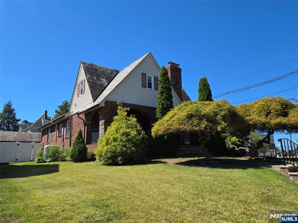 Welcome to this stunning Tudor home 2,320 sq ft offering spacious rooms, timeless character, and plenty of space to enjoy both indoors and out! Stroll past graceful Japanese maple trees and a classic brick exterior before being greeted by a charming front door that opens to a welcoming foyer and paved porch. The living room features rich woodwork, soaring 10-foot ceilings, and a cozy wood-burning fireplace. Flow seamlessly into the elegant dining room and beautifully updated kitchen - complete with a large island and handy pot filler over the stove. The first floor includes two generous bedrooms and a full bath. Upstairs, the entire second floor is dedicated to a luxury master suite with a spa-like bath and relaxing jacuzzi tub. The basement is perfect for entertainment and everyday living, featuring a game room with bar, exercise room, laundry area, pantry, and a convenient half bath. Enjoy gatherings on the back porch overlooking an above-ground pool, with plenty of room for outdoor dining. The fully fenced yard offers privacy and space for everyone. A detached 2-car garage plus driveway space for four cars gives you ample room for vehicles and storage. Close to NYC transport bus and train. This home truly has it all - charm, elegance, and endless possibilities!