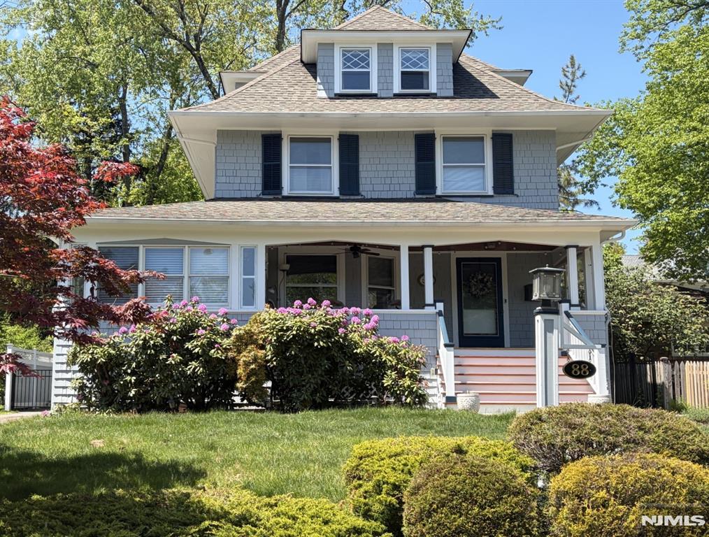 Tucked between two of Montclair's most beautiful parks, and fronting the Edgemont green, this lovingly cared-for and meticulously maintained 1906 four-square Colonial is a treasure. From its delightful East-facing lemonade porch to its bountiful backyard deck, this classic Montclair home offers loads of charm, comfort, and real convenience, close to shops and trains at Watchung Plaza and Upper Montclair. Many original details, from solid brass doorknobs to pocket doors. Enter the elegant foyer with cedar columns and advance into the formal living room with a gas fireplace and period custom mantel built by local craftsman, Jason Aksman. The beamed and wainscoted dining room with bay window and wood-burning fireplace is ready for memorable gatherings. The eat-in kitchen with granite countertops opens onto a spacious deck and fenced backyard perfect for barbecues and socializing. The second floor showcases four bedrooms, including the primary with a wood-burning fireplace. The main bathroom has been recently renovated. The third-floor features two more bedrooms and a tiled bathroom, with access to ample attic space and the high-efficiency one-zone central AC system. The basement is ready for a multitude of uses. A detached two-car garage with electric door openers and concrete floor provides dry storage for vehicles and accessories. Special bonus: a delightful period playhouse adds to the charm. All in all, a sunny, happy Montclair home in one of the prettiest locations in town.