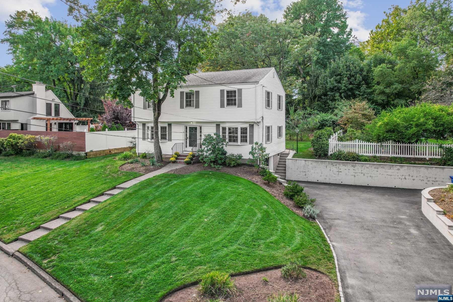 This beautiful center hall colonial sits on a cul-de-sac a short distance from downtown Tenafly and NYC bus stop. The home features hardwood floors throughout, nicely sized rooms, Bay windows, Speaker system, kitchen w/hickory wooden cabinets, an island & high hats, blue stone patio and front steps. It also boasts a formal living and dining room, 4 bedrooms including master with en-suite. The lower level has windows above ground built-in cabinets and shelves & is great flex space for an office/play area. Accessed from lower level is a garage leading to large driveway with ample parking for numerous vehicles. The Generac generator keeps this house going no matter the weather. This home is in close proximity to Tenafly's top rated schools and parks.New roof installed 10/11
