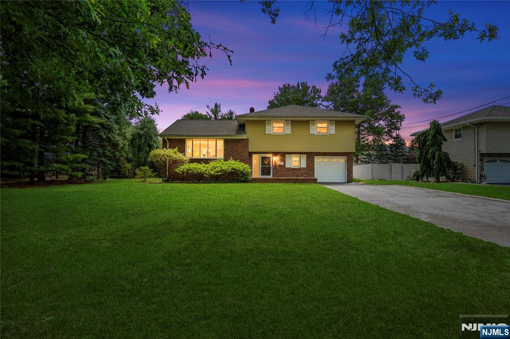 Sellers have requested that all Highest & Best offers be submitted no later than 1:00 pm on Friday, July 17th.... Don't wait. LOCATION, LOCATION, LOCATION! Don't miss this wonderful opportunity to own a spacious split-level home on a picturesque tree-lined street, set on an impressive 75' x 141' level lot. A welcoming entry foyer leads to a comfortable family room with sliding glass doors opening to the large, covered rear patio, a convenient powder room, laundry area, attached one-car garage, and access to the partially finished basement, offering excellent potential for additional finished living space. The main level features a sun-filled living room with a beautiful bay window, a formal dining room, and a generously sized eat-in kitchen. Upstairs, you'll find the primary bedroom with a walk-in closet and private half bath, two additional bedrooms, and a full hall bath. Additional highlights include attic storage, central air conditioning, and hardwood floors beneath the carpeting on the upper levels. Move right in, renovate to your taste, or create the home of your dreams. Ideally located near schools, parks, houses of worship, public transportation, and the vibrant downtown Westwood district, offering an outstanding selection of restaurants, cafes, boutique shopping, and convenient NJ Transit train service. A fantastic home, an exceptional property, and an unbeatable location... don't miss it!