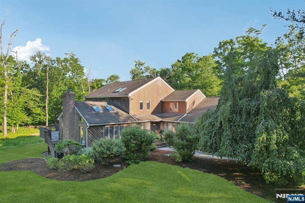 Beautifully updated 5 BR, 3.5 bath Colonial set at the end of a quiet cul-de-sac with serene views of protected woodlands. Move-in ready and filled with custom upgrades, this exceptional home features a dramatic great room with cathedral ceiling, skylights, wood-burning fireplace, wine bar, and sliders to an expansive deck. Just off the formal dining room and living room with built-ins is the bright kitchen offering exquisite cabinetry, quartz countertops, a large center island with 6 burner stove, double ovens, and abundant pantry storage. A 1st floor BR and adjacent full bath provide ideal space for guests, extended family, or an au pair. Upstairs are 4 spacious bedrooms, including a luxurious primary suite with custom millwork, built-ins, electric fireplace, spa-like bath with soaking tub and oversized shower, and a custom walk-in closet. The finished walk-out basement includes a wine room, office, and bonus room, currently used as a music room. Three-car garage with workshop and EV station plus rear storage garage, new AC (2026) and new hot water heater (2026) complete this outstanding home. Move right in and take advantage of all that desirable Upper Saddle River has to offer including its well known, highly regarded schools. You will love living here. For more info, contact Listing Broker Kristin Graves 201-826-6600