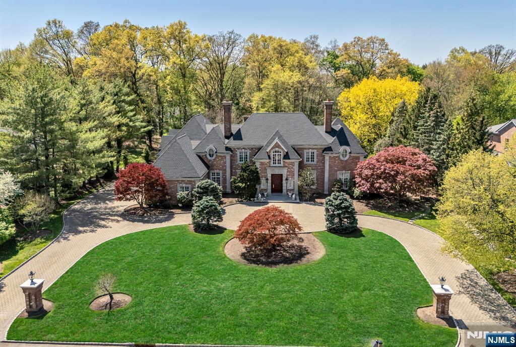 Experience a grand, inviting retreat, crafted by a premier builder and designer, Jim Nigro. This all brick estate rests on a solid, poured-concrete foundation w/ steel support beams, marrying timeless elegance w/ enduring strength. Gracious layout provides options for the discerning buyer including 5 bedrooms, all ensuite, including a stunning primary suite w/ a private balcony overlooking a pristine backyard. The 2 story grand entry soars to 20 feet, featuring a walnut, bridal staircase and custom Enkeboll spindles that greet you w/ timeless warmth and sophistication. Interior woodwork and trim are meticulously handcrafted using only real wood for a rich, enduring beauty throughout. Chef grade comfort meets everyday joy in the Allmilmo kitchen which opens to a spacious breakfast dining area and a private study or playroom, perfect for family gatherings, homework and quiet moments. Formal living and dining rooms, library, the great room and primary bedroom all feature gas fireplaces adding inviting warmth and architectural charm. Lower level is fully finished and updated with modern porcelain tile, offering flexible space. Full house generator, surveillance system, hardwood flooring, circular drive, 3 car garage, specimen trees and a top rated town and schools enhance the appeal. This masterpiece offers a rare blend of grand craftmanship, contemporary comfort and heartfelt warmth, perfect for growing families, entertaining and anyone seeking a refined sanctuary.
