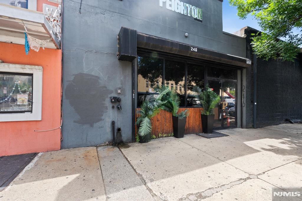 An exceptional turnkey opportunity awaits in this premium 1,800 sf commercial property located in a redevelopment zone. The linear layout maximizes every inch, transitioning from a main lounge into a back-of-house setup and an outdoor oasis. The main lounge area blends contemporary urban flair with upscale comfort. Sleek, marble-patterned flooring spans the interior, contrasted against striking brick feature walls and textured masonry. A prominent dry bar anchors the room, boasting a slatted-wood facade and glass shelving. Accompanied by premium leather booths, this space provides an intimate atmosphere for an upscale lounge experience, complete with two private bathrooms. Behind the scenes, the establishment features a functional prep kitchen designed for quick service. The stainless steel-lined kitchen includes a multi-compartment sink, dedicated glassware shelving, and refrigeration space. In the back of the property you'll discover a spectacular enclosed patio that functions as a private urban escape.
