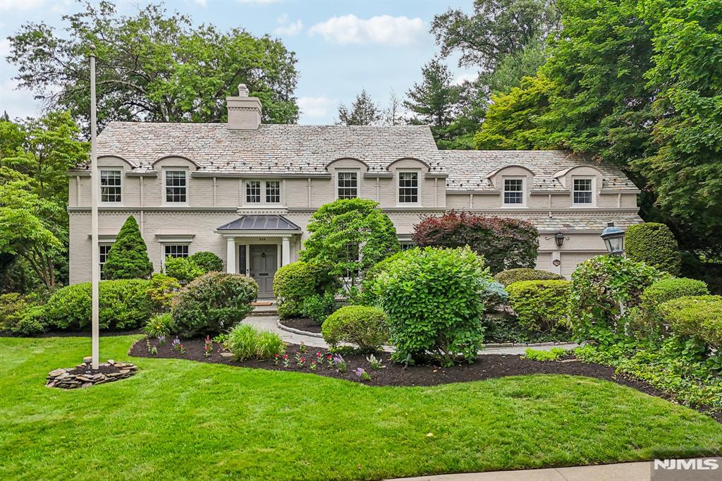 Welcome to this gracious manor-style Colonial, nestled on park-like grounds in the heart of Ridgewood's Old Country Club section. Sunlit rooms with grand scale showcase timeless architecture throughout, including a slate roof, sweeping curved staircase, and elegant living room with Carrera marble fireplace. A stunning dining room and library-style office with custom built-ins and serene garden views enhance the versatile floor plan. The family room is framed by dramatic floor-to-ceiling curved windows, offering breathtaking views of the private garden retreat with koi pond, pool, & pool house. The gourmet kitchen & breakfast room flow seamlessly to expansive patios and resort-inspired outdoor spaces. Upstairs, three generously proportioned ensuite bedrooms offer exceptional comfort & privacy, including a serene primary retreat. Enjoy refined living and an extraordinary indoor-outdoor lifestyle, all with convenient access to everything Ridgewood has to offer.