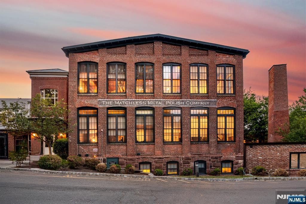 Welcome to The Lofts in the Glen, an award-winning boutique community designed by Sionas Architecture offering SoHo-inspired loft living, surrounded by the stunning tree-lined streets of Glen Ridge. This, spacious true two-bed, two-bath home delivers a bespoke â€œin-townâ€ townhome feel while featuring soaring 12-foot ceilings, exposed brick walls, hand-hewn beams, and abundant natural light. Perfectly located at the back of the complex, this exceptionally private residence is the largest in the community and the ONLY unit with a main-floor primary suite. A generous open layout is anchored by an expansive living area with a gas fireplace and dedicated work-from-home nook. The open-concept kitchen includes a breakfast bar, and flows seamlessly to an intimate dining room, as well as a full-size pantry w/ beverage fridge and espresso bar. The primary suite features a walk-in closet with custom cabinetry and an en-suite bath, with an additional walk-in closet on the floor. Step down to the lower level for a large second bedroom, full bathroom, laundry room, flexible fitness or office space, and French doors leading to an oversized private patio. At 1,961 sq ft, this condo is rare in both scale and character. The unit comes with THREE assigned parking spaces, and is located just two blocks from the Glen Ridge train station, with 35-minute Midtown direct service. The location also offers easy access to downtown Montclair, the Garden State Parkway, and the Jersey Shore.