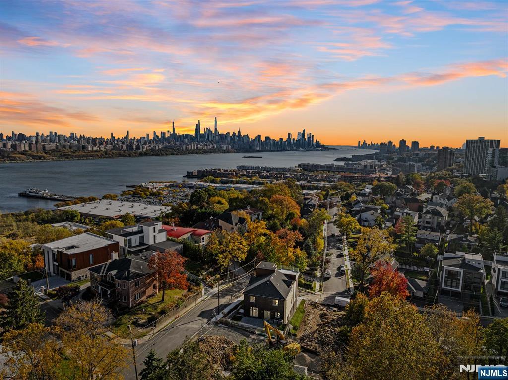 Welcome to 61 Edgewater Road - a new 6,134 square foot architectural masterpiece by Luna Developers, nearing completion in the heart of Cliffside Park. From rooftop entertaining to sleek designer finishes, this four-level home is designed for those who appreciate elevated living which blends contemporary design with thoughtful function. The main level impresses with a sleek European kitchen, butlerâ€™s pantry, additional walk-in pantry, wine display, office, family room, dining and powder room - ideal for both daily life and entertaining. Upstairs, a primary bedroom suite with dual walk-in closets and spacious full bathroom, three additional bedrooms, two more full bathrooms, and a convenient laundry room. The first level features a rec room with wet bar, bedroom and full bathroom perfect for overnight guests, and a generous 2-car garage with plenty of space for lifts. Crowned by a rooftop deck with its own wet bar, powder room, and breathtaking views of Manhattan and the Hudson River, this home is built to impress. Designer details like natural white oak flooring, floating staircase with glass balustrades, designer porcelain tile, 3 zone heat and AC, a built-in whole-house generator, and a smart sound system complete the picture of modern luxury. The virtual tour link includes a comprehensive video tour, an interactive whole-house 3D model, floor plans, and more: https://newjerseyproper.com/mls-61-edgewater-rd-cliffside-park-nj/