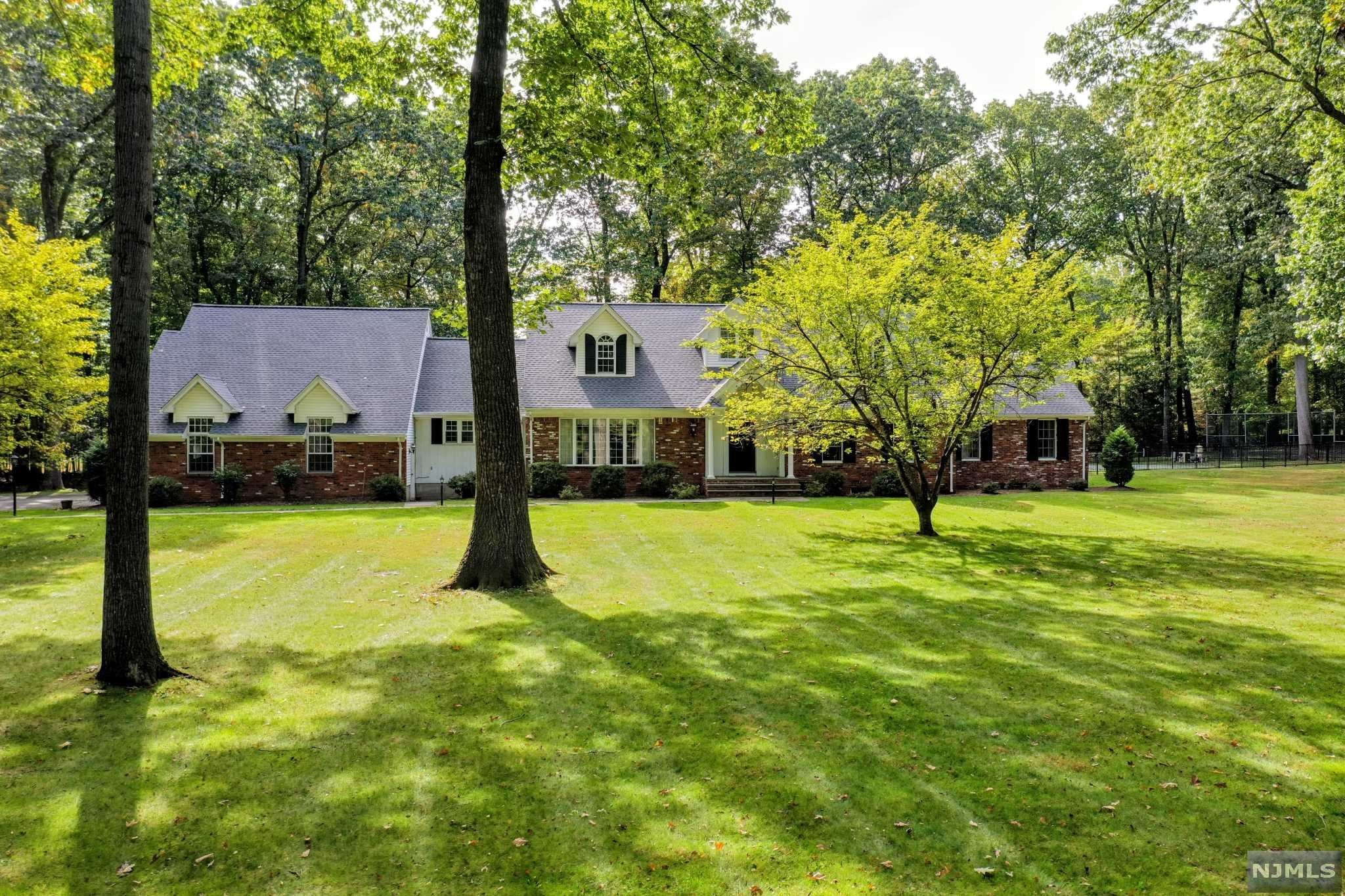 Classic Saddle River home in fantastic neighborhood. This 4 BR, 2 full and 3 half bath home with pool and tennis court offers privacy and large rooms throughout. Elegant foyer leads to a generous living room, a huge dining room for hosting all the holidays, beautiful great room with dual fireplace going into a gorgeous sunroom, large eat-in kitchen and expansive master bedroom suite and laundry room complete the first floor. Three spacious bedrooms, bonus room, full bath and unfinished bonus room complete the second floor. Full finished basement offers a summer kitchen, half bath and separate room. Three car garage, greenhouse, large patio, pool and tennis court offer resort living in your own backyard. This could be your new "Home for the Holidays!"!