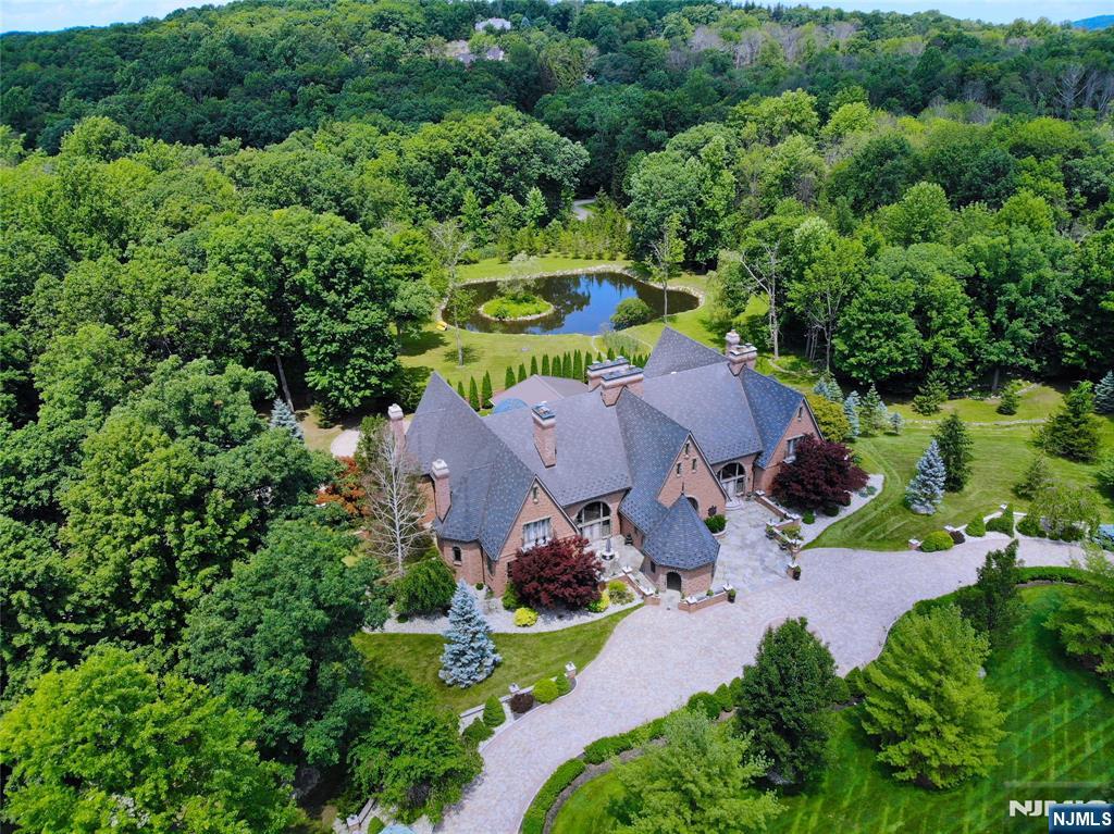 Set on just under five secluded acres, this custom all-brick and stone English manor offers over 13,000 square feet of timeless craftsmanship and resort-style living just one hour from New York City. Featuring soaring ceilings, handcrafted woodwork, expansive windows, and two primary suites on the main level, the home was designed for both grand entertaining and everyday comfort. The estateâ€™s full vision is realized with a resort-style indoor pool, private fitness studio, wine cellar, summer kitchen, and a multi-car garage, creating an exceptional setting for both grand entertaining and discerning collectors. Outside, a picturesque pond, manicured rock gardens, mature specimen trees, and sprawling grounds provide a stunning backdrop throughout every season. Residents enjoy convenient access to the amenities of Lake Mohawk, premier golf courses, dining destinations, and Sussex Countyâ€™s renowned ski resorts, all just minutes away. A truly exceptional estate offering privacy, scale, craftsmanship, and a lifestyle rarely found in one of Sussex Countyâ€™s most coveted locations. Select marketing images have been virtually enhanced or rendered to illustrate potential design concepts and modernization opportunities. Contact Jaclyn Rosenberg at jaclynr@rosemarkgroup.com.