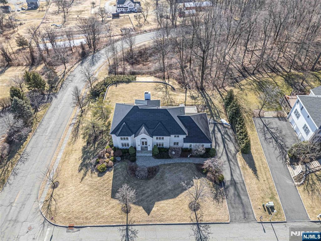 Situated on a peaceful cul-de-sac in one of Denville's most sought-after neighborhoods, this expansive custom home offers an upscale lifestyle & nearly 5,000 sqft of living space. The grand 2-story foyer is flanked by a formal dining room & a large formal living room & a dramatic double curved staircase adds to the home's elegance.The heart of the home is the FR, which boasts cathedral ceilings & a gas fireplace, creating an inviting space for entertaining which seamlessly flows into the eat-in kitchen. Large windows bathe the home in natural light. The 1st floor also includes a study or optional bdrm w/a full bath close by. Upstairs, there are 4 more bdrms, 2 of which have private en-suites & walk-in closets. If this home isn't impressive enough, the Solar Roof shingles & power will steal the show! Powers the home 24/7 & through all outages. The glass solar tiles & steel roofing tiles look great up close & from the street, complementing the home's classic style.