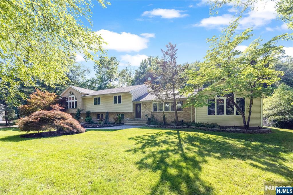 Welcome to 61 Brookview Avenue, a 4,000-square-foot updated split-level home in one of Woodcliff Lake's most sought-after neighborhoods. This 4-bedroom, 4-bath residence offers a flexible layout suited for today's lifestyles, including extended living arrangements. The main level features vaulted ceilings, hardwood floors, and two wood-burning fireplaces that anchor the living and family rooms. An expansive, updated kitchen and dining area flow seamlessly for everyday living and entertaining. The large, expanded primary suite is a standout, offering a spa-like bathroom, his-and-her walk-in closets, and an exercise room. Additional bedrooms are well proportioned, with access to full baths, and a bonus room provides options for an office, media room, or guest space. The resort-style backyard is designed for seasonal enjoyment, with multi-level patios and a heated gunite in-ground pool creating a private outdoor retreat. This property combines generous interior space, thoughtful updates, and a premier Woodcliff Lake location, presenting a strong opportunity for buyers seeking a move-in ready home with substantial amenities.