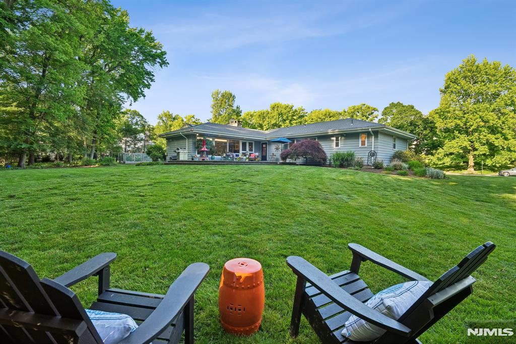 In a town filled with beautiful homes, this may be one of the most irreplaceable settings in Montclair. Positioned along the park side of Yantacaw Brook Road, this exceptional mid-century ranch enjoys a private setting with protected green space as a natural backdrop. Clean architectural lines, oversized windows, & effortless indoor-outdoor flow capture everything we love about mid-century design. Designed for easy living, the layout offers generous space across two levels. The main level unfolds where light-filled rooms connect seamlessly to the landscape beyond. Walls of glass invite the outdoors in, while the home's timeless architecture balances openness, comfort, & character. At the center, the kitchen serves as a natural gathering place, connecting the principal living & entertaining spaces. Downstairs, a spacious recreation room offers space for movie nights, game days, hobbies, fitness & home office needs. The highlight is the expansive bluestone terrace. Here, morning coffee comes with birdsong, afternoons invite conversation, & evenings bring a sense of peace that's rare. With the park as your backdrop, life feels serene & removed from the everyday. Yet this tranquil retreat is less than a mile from Upper Montclair's restaurants, coffee shops, boutiques, & NYC transportation. Just 13 miles from Manhattan, 95 Yantacaw Brook Road offers a rare balance of iconic mid-century architecture, natural beauty & convenience.