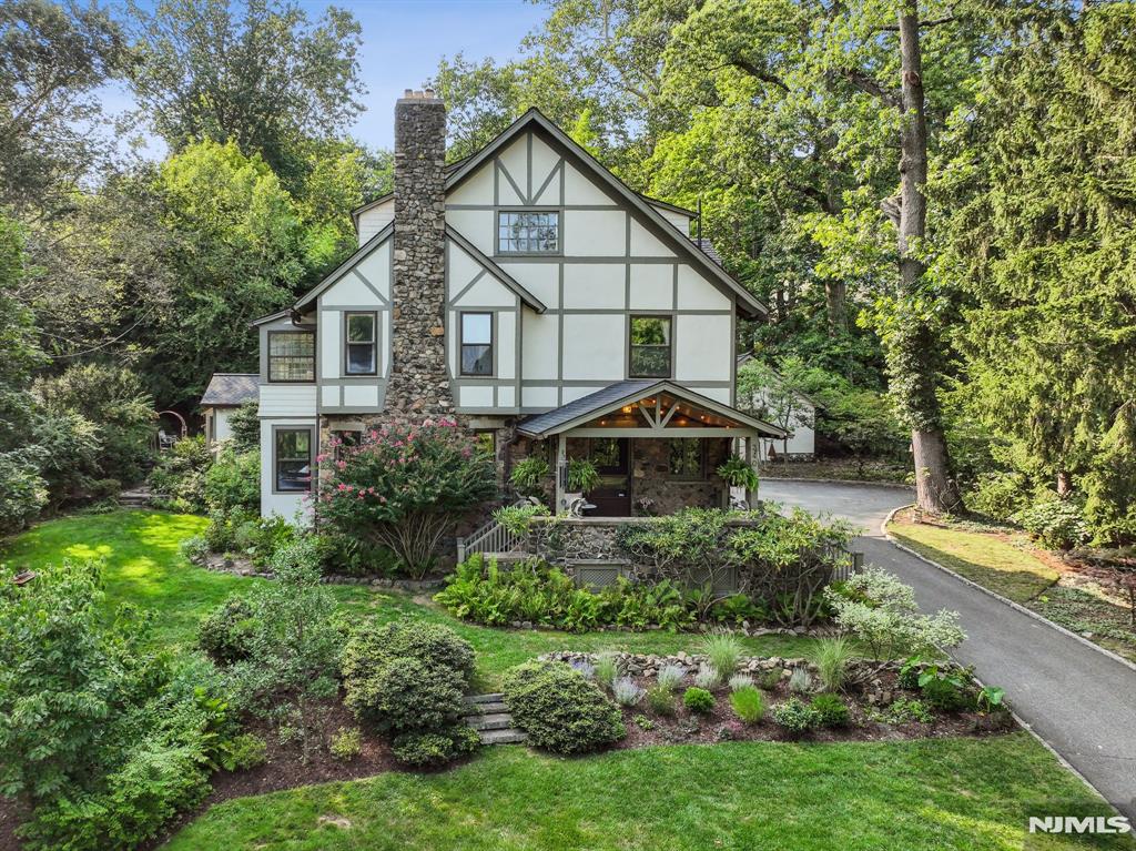 Craftsman Soul. Modern Ease. A Hidden Retreat in the Heart of Upper Montclair. Perched on nearly half an acre and tucked just enough off the road to feel worlds away, this 1897 Craftsman blends rich architectural detail with the flow, light, and comfort of contemporary living. Original Chestnut millwork, etched Venetian and stained-glass windows, and a welcoming Dutch door speak to its artistry while thoughtful updates create a home that feels fresh, effortless, and beautifully livable. Five bedrooms & 3.5 baths, including a serene primary suite with a spa-like en-suite. An incredible vaulted family room is the everyday gathering space sunlit, soaring, and seamless to the outdoors. Step out to a fully fenced oasis: expansive bluestone patio, Hudson River stone waterfall, lush perennial gardens and lawn dinner parties, quiet mornings, barefoot summers all here. The lower level brings a calm, retreat-like vibe with a sauna and flexible fitness/rec space. A rare first-floor office with its own private entrance makes WFH feel separate yet connected. And the location? Pure Montclair magic. A short half-mile stroll to Upper Montclair Village shopping, cinema, fitness studios, standout restaurants and the Olmsted-designed beauty of Anderson Park. NYC direct train right there, too. Maine-like tranquility just minutes from everything. Architectural character, modern comfort, city views, and a setting that stays with you.