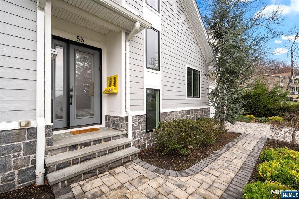 This stunning 5-bedroom Colonial by Lumaj Builders is tucked away on a quiet street in highly sought-after Cresskill. Built only 4 years ago and thoughtfully upgraded throughout, the home offers a bright living room with fireplace, formal dining room, eat-in kitchen, powder room, mudroom, and attached 2-car garage. The second floor features a spacious primary suite with walk-in closet and a luxurious primary bath with radiant heated floors, plus an en-suite bedroom, two additional bedrooms, and a Jack-and-Jill bath. The beautifully finished lower level includes a bedroom, full bathroom, wet bar, recreation area, and pre-installed dehumidifier, making it ideal for both everyday living and entertaining. Additional highlights include radiant heated bathroom floors, whole-house sound system, full-house generator, Google Nest smart-home wiring, Nest doorbell, central vacuum, Tesla EV charger, and a brand-new dishwasher. Outside, enjoy a private backyard with a patio, perfect for relaxing or entertaining. Located in a wonderful town with excellent schools and easy access to NYC, this home offers the perfect blend of luxury, comfort, and convenience.