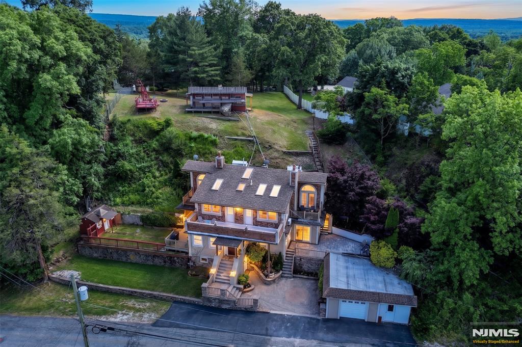 Nestled on nearly an acre, this one-of-a-kind custom home is waiting to be your own private oasis! Three separate areas to play, relax and entertain, will make every day feel like youâ€™re on vacation. Barbeque on the spacious deck, unwind on the patio beside a tranquil waterfall, or enjoy the expansive backyard featuring a lookout area with stunning sunsets views, a fire pit to keep you warm during cool nights, plus a zip line and an impressive tree house for playtime. Equally as fabulous is interior of this home which offers a warm and inviting living room, with gleaming hardwood floors and a wood burning fireplace. The large eat in kitchen, with stainless steel appliances, updated light fixtures and an oversized island/ breakfast nook is the perfect place to gather and share meals. Completing the first floor is a powder room and the newly renovated full dining room, that leads directly to the patio. On the second floor, an abundance of natural light adorns each of the four generously sized bedrooms. Each bedroom boasts high ceilings, skylights, multiple closets, an attached bathroom and a balcony. A conveniently located second-floor laundry area serves all bedrooms. Recent updates include: Patio Pavers (2026); Boiler (2025); Central Air, Ductless AC in DR, Dishwasher, Washer/Dryer, Garbage Disposal, Water Heater, Bedroom Carpet, Kitchen and Dining Room Light Fixtures, Heater in Primary Bath (2024).