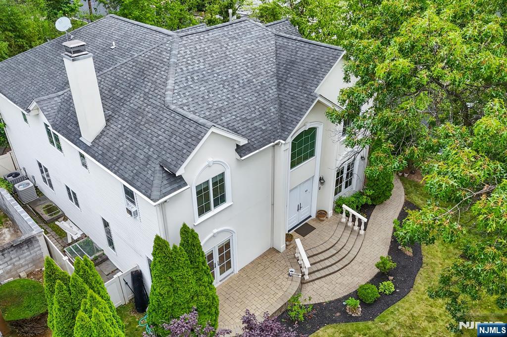 Welcome to this stunning 4-bedroom, 4.5-bath Center Hall Colonial offering over 4,000 sqft of refined living space. Designed for both comfort and style, this home features hardwood floors throughout, expansive windows, and a whole-house intercom and audio system. A private elevator effortlessly connects all three levels, adding both luxury and ease. The main level includes a formal sitting room/study, a sunken living room with fireplace, and a bright family room with elegant tray ceilings. The spacious eat-in kitchen is a chefâ€™s dream, complete with a center island, breakfast nook, and door leading to a serene, paved backyardâ€”ideal for relaxing or entertaining. Upstairs, youâ€™ll find four bedrooms, including a luxurious primary suite with Juliet balcony, dual walk-in closets, and a beautifully renovated bath. A second en-suite bedroom, two additional bedrooms, and a full hall bath complete the upper level. The fully finished basement offers impressive ceiling height and versatile living options with two additional rooms, a spacious main room, full bath, and a kitchenetteâ€”perfect for guests, home office, or recreation. Located just minutes from NYC, this home combines timeless design with modern amenities and an unbeatable location.