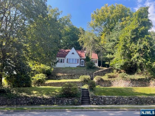 "Suburban in the Front - Adirondacks in the Back". This timeless charmer is a Sears & Roebuck catalog home sitting atop the hill along N. Franklin Turnpike. The home needs renovations to bring it to modern standards. Two sections of the property are separated by a private road. The house sitting on the front property is a 4 bedroom, 2 bath colonial with detached one car garage. Seven stone walls, one serpentine, and a staircase designed and laid by master craftsmen grace the property. The first floor has a small kitchen, dining room, living room with wood burning fireplace, 2 bedrooms and full hallway bath. The second floor has two bedrooms and full hallway bath. There is a full unfinished basement. The rear property, on the other side of the private road, is wooded with a flat surface before falling away to the HHK Brook and HHK Ravine. A new roof was completed in 2023. This is a prime location in the premier town of HHK that offers privacy, access to NYC transportation, top rated schools, nearby restaurants, the library and it is surrounded by luxury properties.