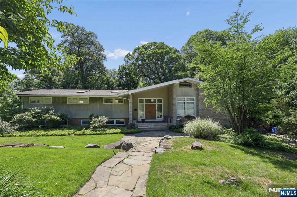 This contemporary dream w/130 X 259 lot size on the East Hill of Tenafly features 4/5 bedrooms & 4 full bathrooms! Enter into incredible natural light that sprawls across gorgeous hardwood floors; thanks to a plethora of over sized & panoramic windows in this open floor plan dream residence. Formal living room w/radiant heat & family room offer beautiful views, while the elegant dining area boasts easy access to impressive MEIK kitchen. Fit for a chef w/a center island, kitchen has beautiful cabinetry, top-notch appliances, fireplace, radiant heat & entry to deck. Primary bedroom suite also spacious & bright w/large bathroom; fabulous double vanity and tub. Two additional bedrooms & full bathroom on 1st level. Enjoy natural gas generator & fully finished basement with rec room, bedroom, studio/bedroom, 2 full bathrooms, laundry, pantry, & wine cellar. Backyard patio is truly made for entertaining. & 2 car-garage makes storage easy. Close to schools, shopping & NYC transportation!