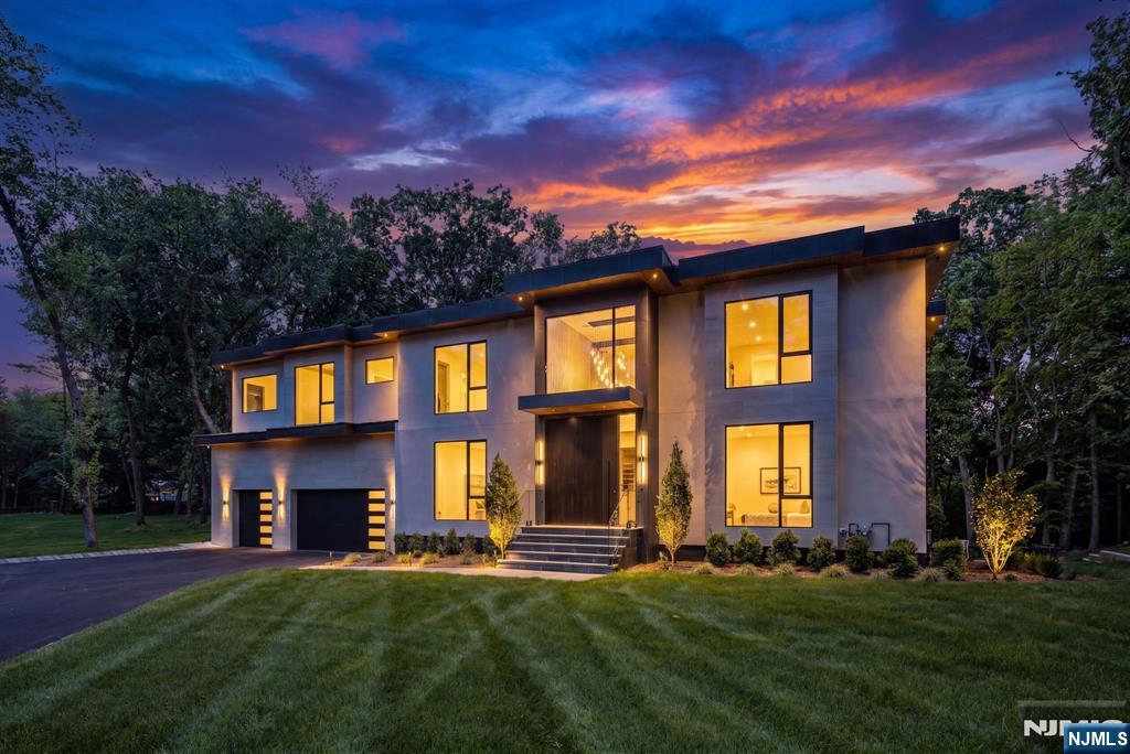 Experience the pinnacle of modern luxury in this extraordinary approximately 9,000 sq. ft. new construction estate on 2 private acres in Franklin Lakes. A true architectural masterpiece, this residence blends sophisticated design, impeccable craftsmanship, and resort-style amenities. A dramatic double-height foyer with floating glass railings and designer lighting welcomes you into expansive living spaces and a stunning chef's kitchen featuring Taj Mahal quartz, custom cabinetry, a walk-in pantry, and butler's pantry. Smoked glass accents and contemporary finishes elevate every room. Offering 5 bedrooms, including a first-floor guest suite and four upstairs bedrooms, the home features three en-suites and a spectacular primary retreat with a gas fireplace, private balcony, dual walk-in closets, and a spa-inspired bath. The walkout lower level is designed for wellness and entertaining with a yoga studio/gym, sauna, wet bar, recreation room, bonus media room, and direct access to the backyard. Outdoors, enjoy a heated saltwater pool surrounded by porcelain tile patios, creating a private resort-like setting. Combining bold architecture, luxurious finishes, and exceptional amenities, this one-of-a-kind Franklin Lakes residence delivers an unparalleled lifestyle for the most discerning buyer.