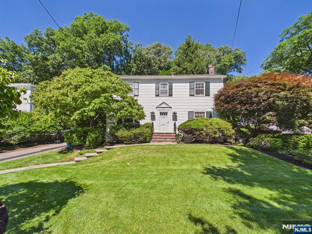 Stunning center-hall Colonial on a favorite street in the Ridge School area...and boasting beautiful curb appeal! A welcoming entry hall opens to a large Living Room with fireplace on the right and to a formal Dining Room on the left. The updated Kitchen with center island and Corian counters offers convenient cooking space. An adjacent sitting/eating area overlooks the private back yard and opens to a screened porch. There is also a Powder Room on this level. On the second floor are 4 good-sized corner bedrooms and two full baths. The primary bedroom has an ensuite bath with shower and 2 large closets. The hall bath has a shower over tub. A large, paneled Family Room is on the lower level along with the laundry, storage including a cedar closet, a half bath and the utilities. There is a separate 2-car garage with electric door opener and a deep back play-yard. Throughout the house are beautiful hardwood floors, pretty moldings, and good closet space. Gas/hot air heat and central air. Convenient to schools, transportation and town. Ready for you to move right in!