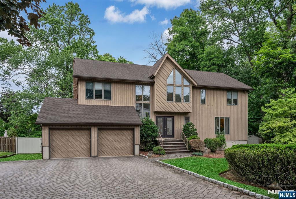 Nestled on a quiet cul-de-sac in Closter's desirable East Hill neighborhood, this beautifully maintained contemporary Colonial offers 4 bedrooms, 3 full and 1 half bathrooms, and a bright, open floor plan designed for comfortable everyday living and entertaining. Set on approximately half an acre of private, fenced property, the home is filled with natural light, soaring ceilings, and hardwood floors throughout. The first floor features a spacious living room, formal dining room, laundry room, powder room, and a stunning two-story great room with cathedral ceilings that opens seamlessly to the updated eat-in kitchen. Thoughtfully designed with abundant cabinetry, generous workspace, and sliders to an oversized composite deck, the kitchen is both practical and inviting for gatherings of any size. Upstairs, the second level offers four generously sized bedrooms and two full bathrooms, including a spacious primary suite with two walk-in closets and a luxurious primary bath. The expansive deck overlooks the beautiful fenced backyard and pool, creating the perfect setting for outdoor entertaining, relaxation, and recreation. Offering privacy, space, and an exceptional location just minutes from the George Washington Bridge, this home is conveniently located near Closter's elementary school, parks, playgrounds, and vibrant downtown filled with popular shops, restaurants, and everyday conveniences. A wonderful opportunity to enjoy the best of East Hill living.