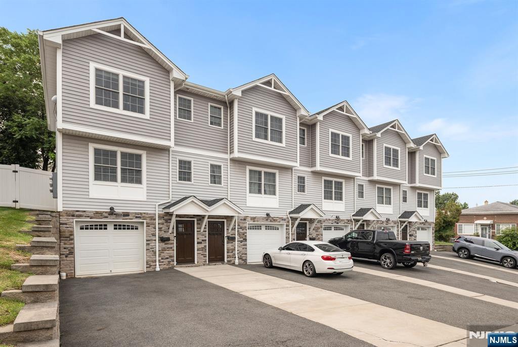 Welcome home to this impeccable end-unit townhome offering three levels of stylish, sun-filled living space! Enter through the attached one-car garage to a versatile ground-level bonus room that can serve for many different uses. The main living level showcases an open-concept design with beautiful gleaming hardwood floors, a spacious living room, dining area, kitchen, and convenient powder room. Sliding glass doors open to a private deck, creating the perfect space for morning coffee, outdoor dining, or entertaining guests. Upstairs, unwind in the spacious primary suite featuring a walk-in closet and private ensuite bath, along with a second generously sized bedroom, full bathroom, and conveniently located laundry area. A walk-up attic provides exceptional storage, while central air and forced hot air ensure year-round comfort. A commuter's dream! Easy access to NYC with nearby Plauderville Station. Combining style, comfort, and functionality, this move-in-ready end-unit offers the perfect place to call home!