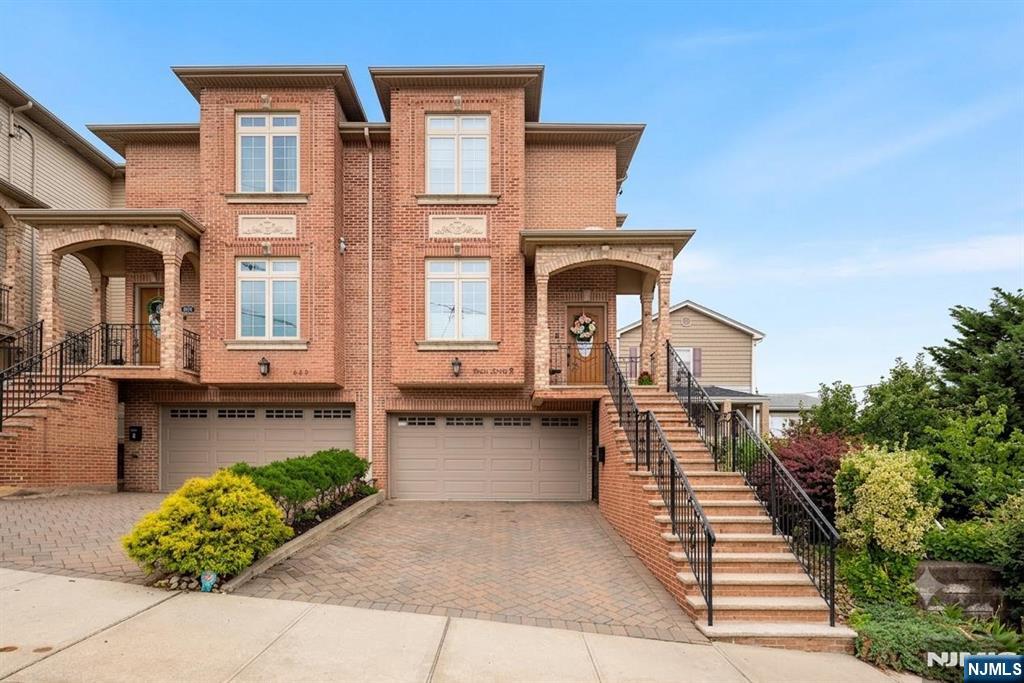This oversized townhome delivers extra width, more space, and a grander presence. Perched atop the hill with abundant natural light. Impeccably maintained by original owners.The expansive living room features diagonal oak flooring, gas fireplace, and formal dining area with beautiful sunsets, perfect for entertaining. Separate kitchen area offers space for a family room, eating, or office. Currently used as an eat-in kitchen with den. Custom cabinets, island, quartz counters, GE appliances, and a high-powered range hood vented outside. Custom beverage center with wine fridge. Step out to the south-facing private Trex terrace. Spacious powder room completes the first floor. Upstairs, high ceilings and a skylight lead to the oversized primary suite. Vaulted ceilings and an impressive picture window frame open sky views from this hilltop setting. Room for a king bed, full furniture set, and private sitting area bathed in light. Rich hardwoods, recessed lighting, and meticulous upkeep complete this retreat. Spa-inspired primary bath with glass-enclosed shower and deep soaking tub beneath a large window catching Meadowlands sunset views. Floor-to-ceiling tile, mosaic accents, and double vanity with stone top. Additional bedrooms are spacious with vaulted ceilings. Ground floor offers den, 4th bedroom with closet, full bath. 2-car garage, 3-zone heat, 2-zone AC. Unbeatable Fairview location near Edgewater, shopping, and NYC transit!