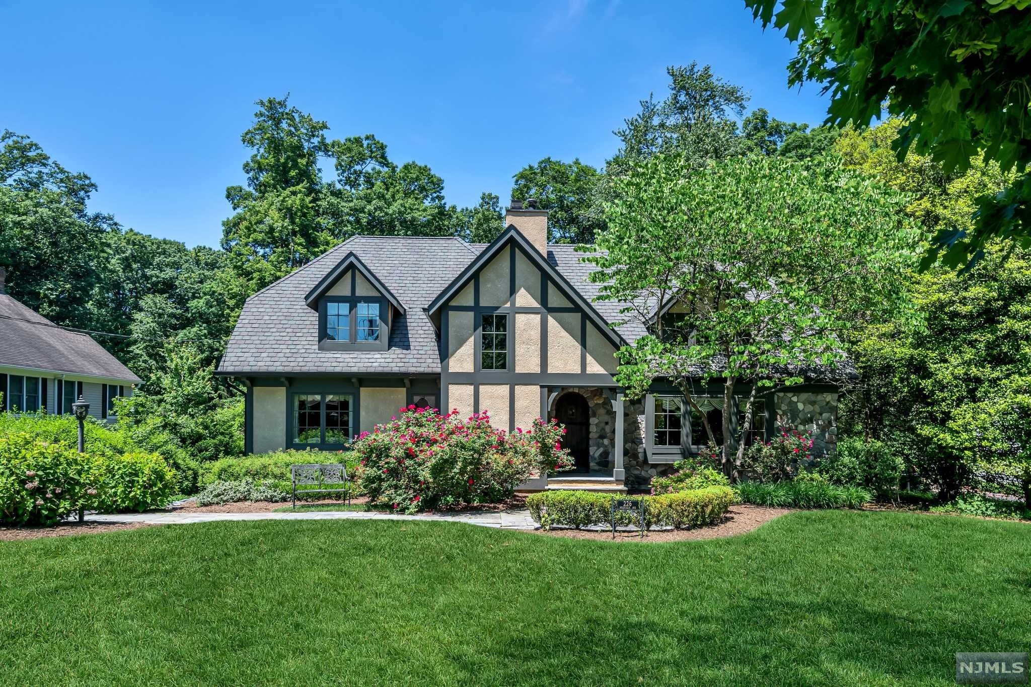 Perfectly perched on a gorgeous 3/4 acre lot on one of the most desirable streets in town, this custom country manor exudes warmth and exquisite craftsmanship. No detail was overlooked in the 2006 planning and building of this home, from the flexible open floor plan, to the window placement that captures maximum sunlight, to the quality woodwork and moldings throughout. Striking features include the banquet size dining room with two-story vaulted ceiling with wood beams, and an adjacent butler's pantry with bar area and walk-in closet; and a breathtaking gourmet kitchen, complete with a 12' island, luxury appliances, and French doors opening to a spacious deck. The primary bedroom is the perfect retreat, with its private balcony, walk-in closets, spa bath, and beverage bar. The 323' deep property has an amazing privacy buffer and stunning views in all seasons. A rare opportunity to balance prime location, newer construction, and unique charm!