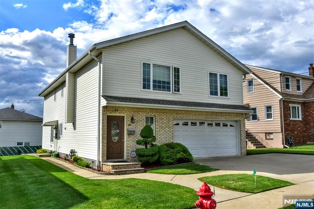 Beautiful Top and Bottom style 2 family home. Top floor owner occupied. Bottom floor has great tenant until January 2027. Top floor will be delivered vacant. Stunning high cathedral ceilings with skylight windows. Very well maintained home close to all major highways. Easy commute to New York City. Close to schools and houses of worship. Both central air units newer/as well as the roof. Pride of ownership shows throughout home. 2 Car attached garage. Beautiful rear deck. Come for a tour today!! Top floor contains alarm system and ring camera. Home being sold "as is" in good condition. All fixtures included, appliances, and all window treatments included.